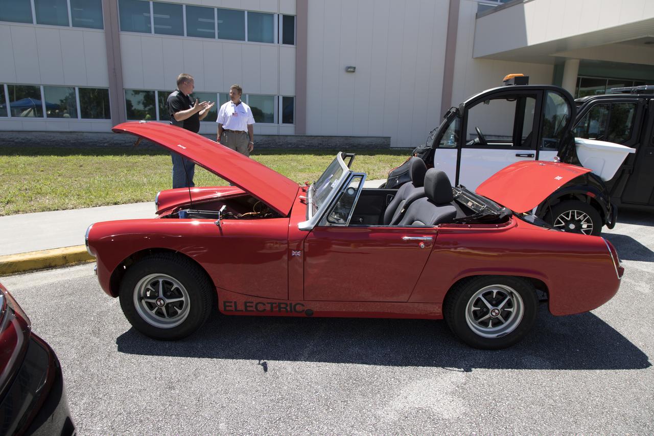 Employees discuss one of the electric vehicles on display during Kennedy Space Center’s annual Earth Day celebration. The two-day event featured approximately 50 exhibitors offering information on a variety of topics, including electric vehicles, sustainable lighting, renewable energy, Florida-friendly landscaping tips, Florida’s biking trails and more.