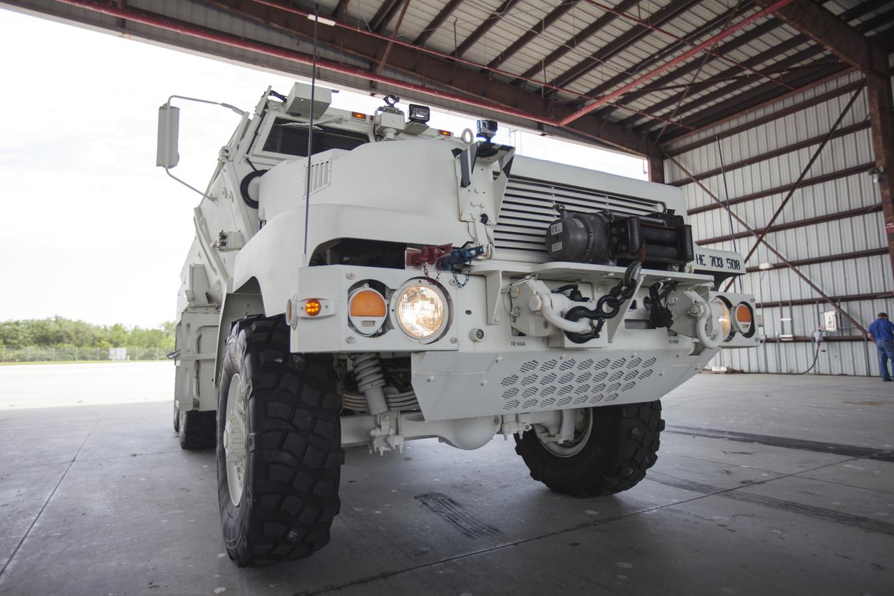 Inside a Shuttle Landing Facility hangar at NASA's Kennedy Space Center in Florida, an MRAP armored vehicle is prepared for a training drive to support the agency's Commercial Crew Program. The 45,000-pound mine-resistant ambush protected vehicle, or MRAP, was originally designed for military applications. The MRAP offers a mobile bunker for astronauts and ground crews in the unlikely event they have to get away from the launch pad quickly in an emergency.