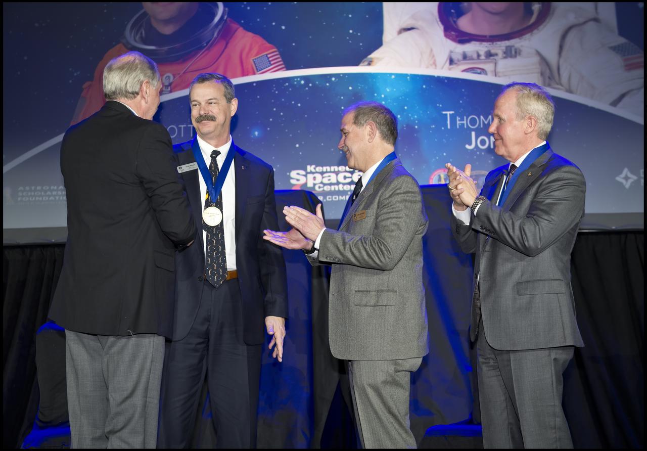 Scott D. Altman, second from left, is inducted into the Astronaut Hall of Fame (AHOF) during a ceremony inside the Space Shuttle Atlantis attraction at NASA's Kennedy Space Center Visitor Complex in Florida. At far left, Hall of Famer Curt Brown, board chairman, Astronaut Scholarship Foundation (ASF), inducts Altman into the Hall of Fame Class of 2018. At right is Hall of Famer John Grunsfeld, who spoke on Altman's behalf during the ceremony. At far right is Thomas D. Jones, Ph.D., who also was inducted into the AHOF Class of 2018. Inductees into the Hall of Fame are selected by a committee of Hall of Fame astronauts, former NASA officials, flight directors, historians and journalists. The process is administered by the Astronaut Scholarship Foundation. To be eligible, an astronaut must have made his or her first flight at least 17 years before the induction. Candidates must be a U.S. citizen and a NASA-trained commander, pilot or mission specialist who has orbited the earth at least once. Including Altman and Jones, 97 astronauts have been inducted into the AHOF.
