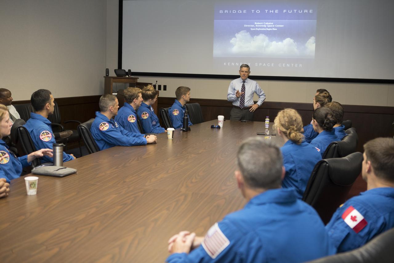The 2017 class of astronaut candidates listen to NASA Kennedy Space Center Director Bob Cabana, standing, during their tour and familiarization with the center. The candidates toured center facilities, including the Vehicle Assembly Building, Launch Control Center, Neil Armstrong Operations and Checkout Building, Launch Pad 39B, and the Space Station Processing Facility. They also toured Boeing's Commercial Crew and Cargo Facility, United Launch Alliance's Space Launch Complex 41 at Cape Canaveral Air Force Station, and SpaceX's Launch Pad 39A at Kennedy. The candidates will spend about two years getting to know the space station systems and learning how to spacewalk, speak Russian, control the International Space Station's robotic arm and fly T-38s, before they're eligible to be assigned to a mission.