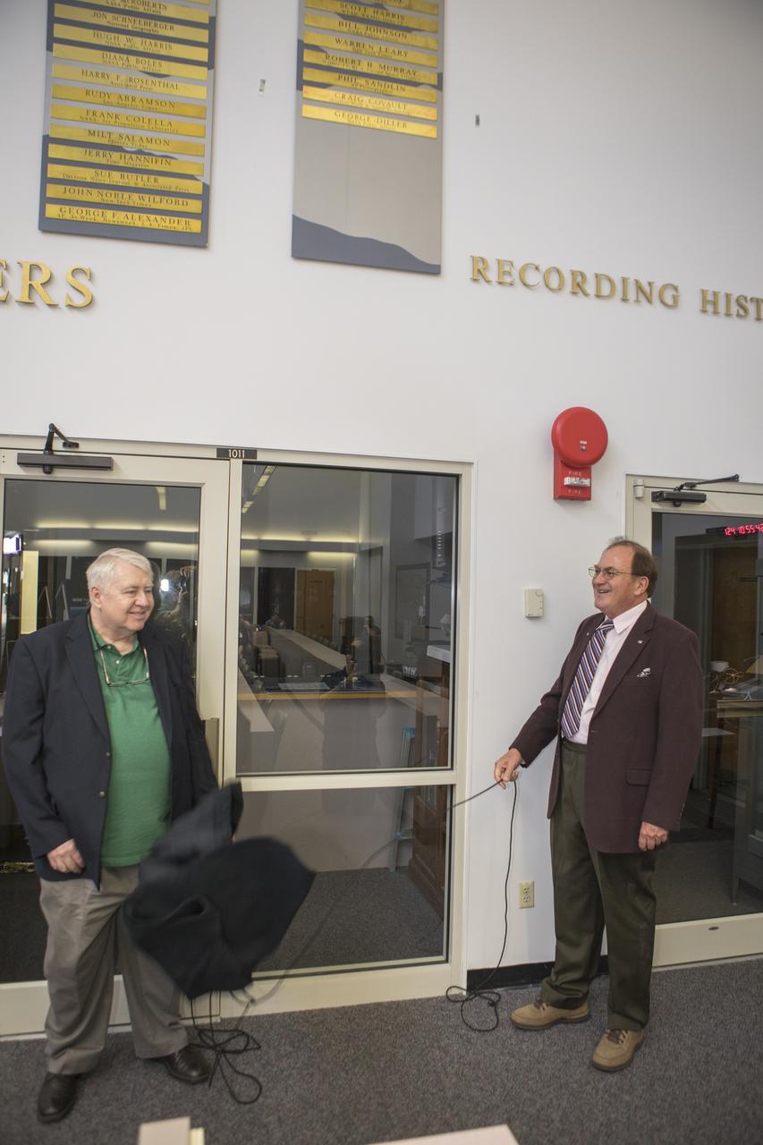Craig Covault, left, and George Diller unveil their names on the “Chroniclers wall” during a gathering of the honorees’ friends, family, media, and current and former NASA officials at Kennedy Space Center’s NASA News Center in Florida on Friday, May 4. “Chroniclers” recognizes retirees of the news and communications business who helped spread news of American space exploration from Kennedy for 10 years or more. The two men combined for 85 years of U.S. space exploration coverage. 