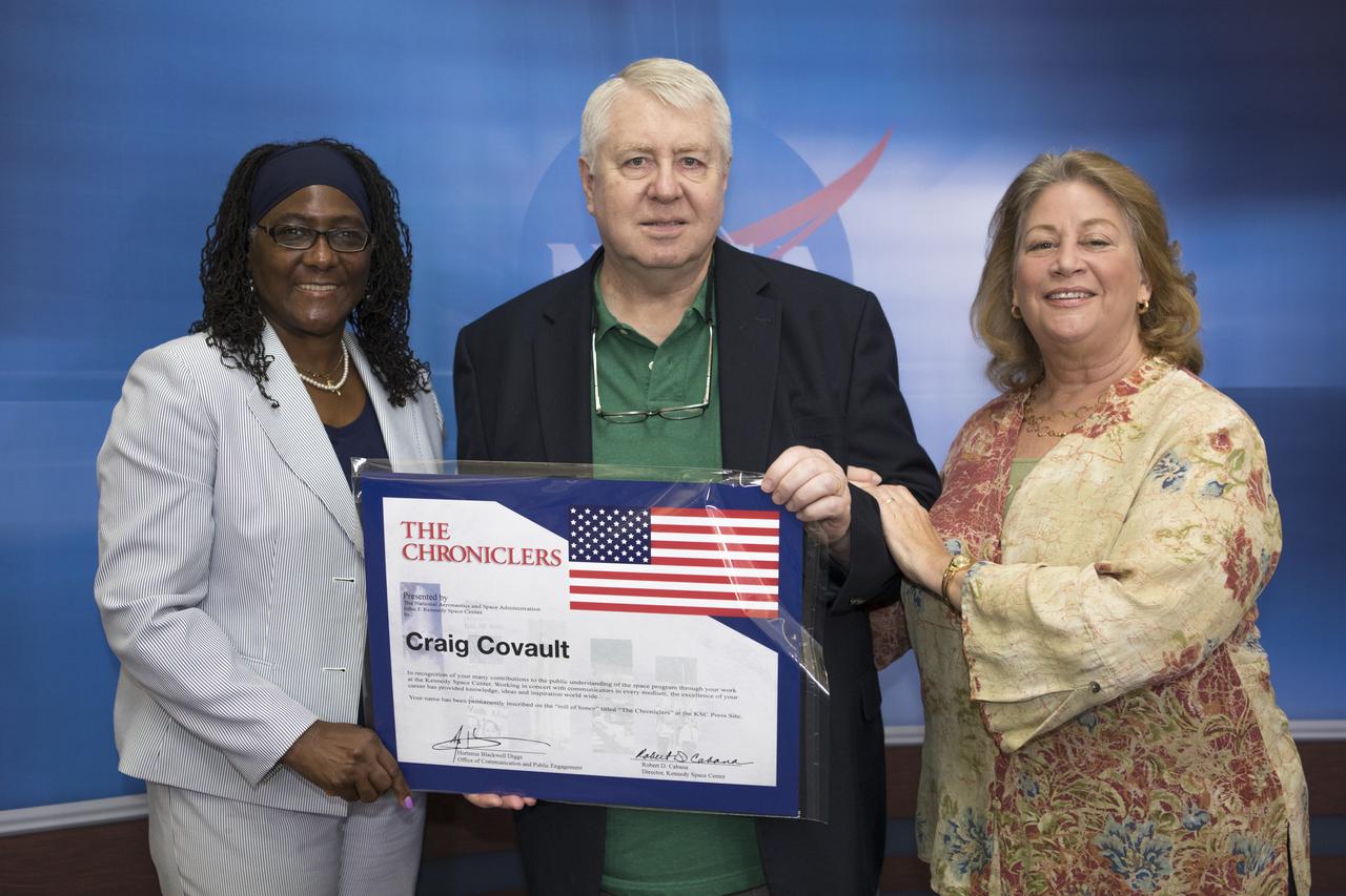 Craig Covault and George Diller were honored as the 75th and 76th members of the “Chroniclers” roll of honor during an event at Kennedy Space Center’s NASA News Center in Florida on Friday, May 4. From left to right are Hortense Diggs, deputy director of Kennedy’s Office of Communication and Public Engagement, Craig Covault, and Covault’s wife, Nancy. “Chroniclers” recognizes retirees of the news and communications business who helped spread news of American space exploration from Kennedy for 10 years or more.  