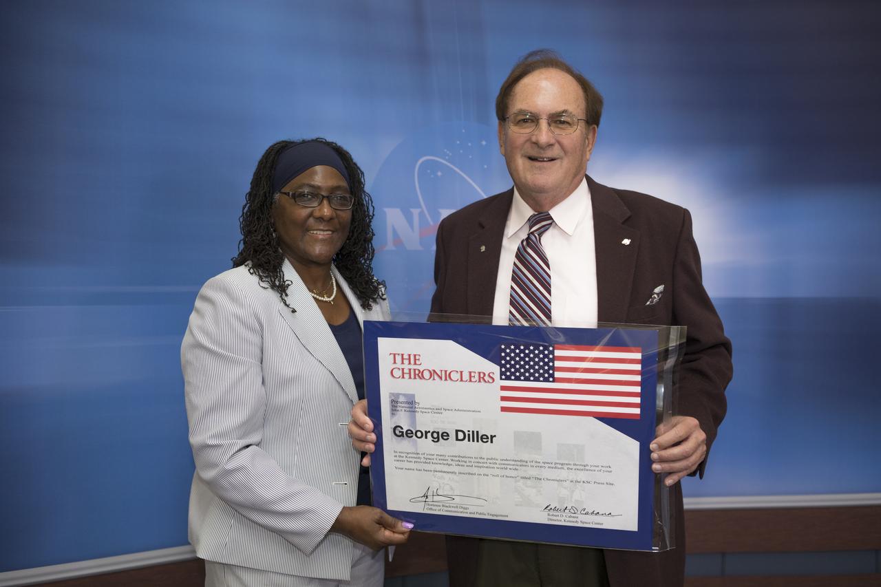 Kennedy Space Center Office of Communication and Public Engagement Deputy Director Hortense Diggs, left, poses with “Chronicler” George Diller during an event at Kennedy’s NASA News Center in Florida on Friday, May 4. Diller, who retired in 2017, had a 37-year career in NASA Public Affairs. “Chroniclers” recognizes retirees of the news and communications business who helped spread news of American space exploration from Kennedy for 10 years or more. 