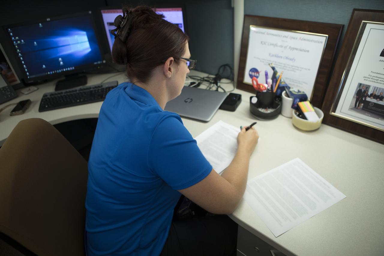 Kathleen O'Brady reviews documents in her office at NASA’s Kennedy Space Center in Florida. As a certification systems engineer in the Commercial Crew Program’s (CCP's) Systems Engineering and Integration Office, she is responsible for defining an integrated plan for certification which is being executed by the agency's CCP partners Boeing and SpaceX. The two companies are developing spacecraft to fly NASA astronauts to the International Space Station and return them safely home.