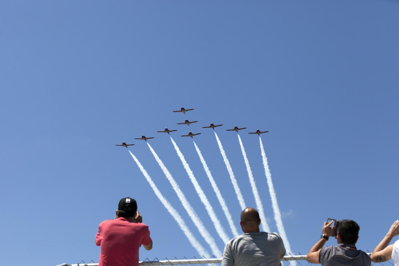 Workers along the NASA Causeway at NASA's Kennedy Space Center in Florida watch a practice flight of the Canadian Forces Snowbirds on May 9, 2018, between their scheduled U.S. air shows.