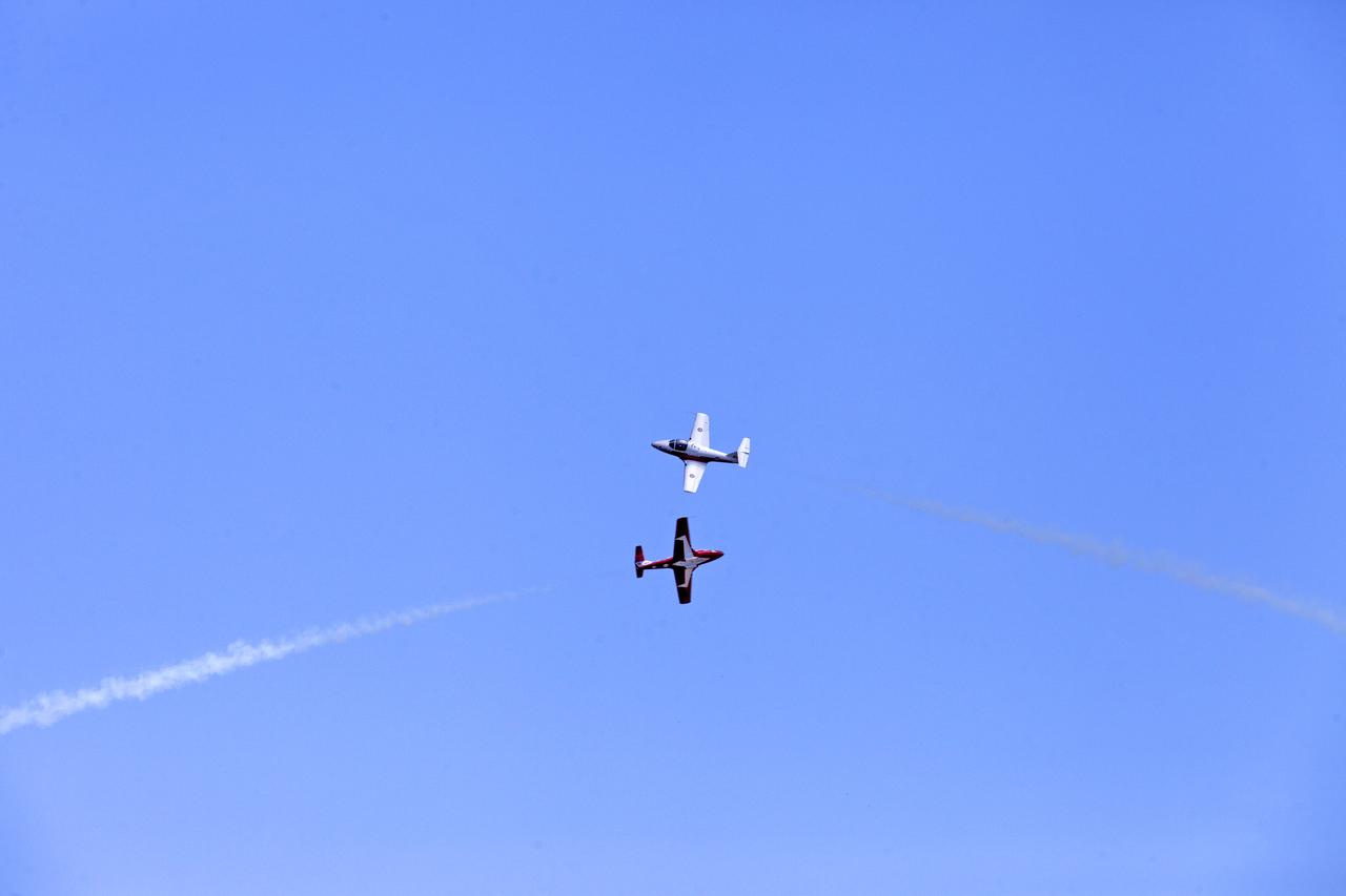 Two Canadian Forces Snowbirds perform a close flyby maneuver over NASA's Kennedy Space Center in Florida during a practice flight on May 9, 2018, between their scheduled U.S. air shows.