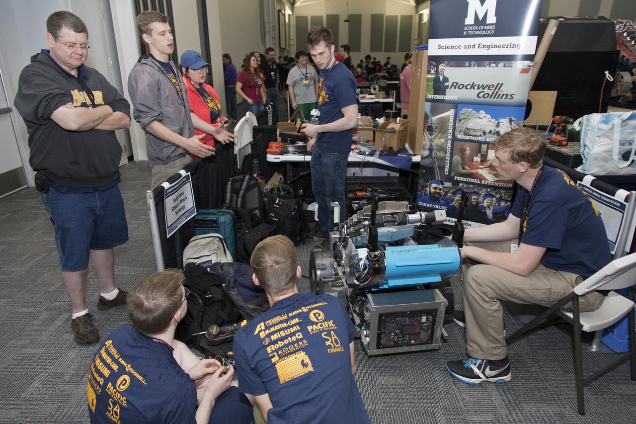 On the first day of NASA's 9th Robotic Mining Competition, set-up day on May 14, team members from the South Dakota School of Mines & Technology work on their robot miner in the RobotPits in the Educator Resource Center at Kennedy Space Center Visitor Complex in Florida. More than 40 student teams from colleges and universities around the U.S. will use their mining robots to dig in a supersized sandbox filled with BP-1, or simulated Lunar soil, gravel and rocks, and participate in other competition requirements. The Robotic Mining Competition is a NASA Human Exploration and Operations Mission Directorate project designed to encourage students in science, technology, engineering and math, or STEM fields. The project provides a competitive environment to foster innovative ideas and solutions that could be used on NASA's deep space missions.