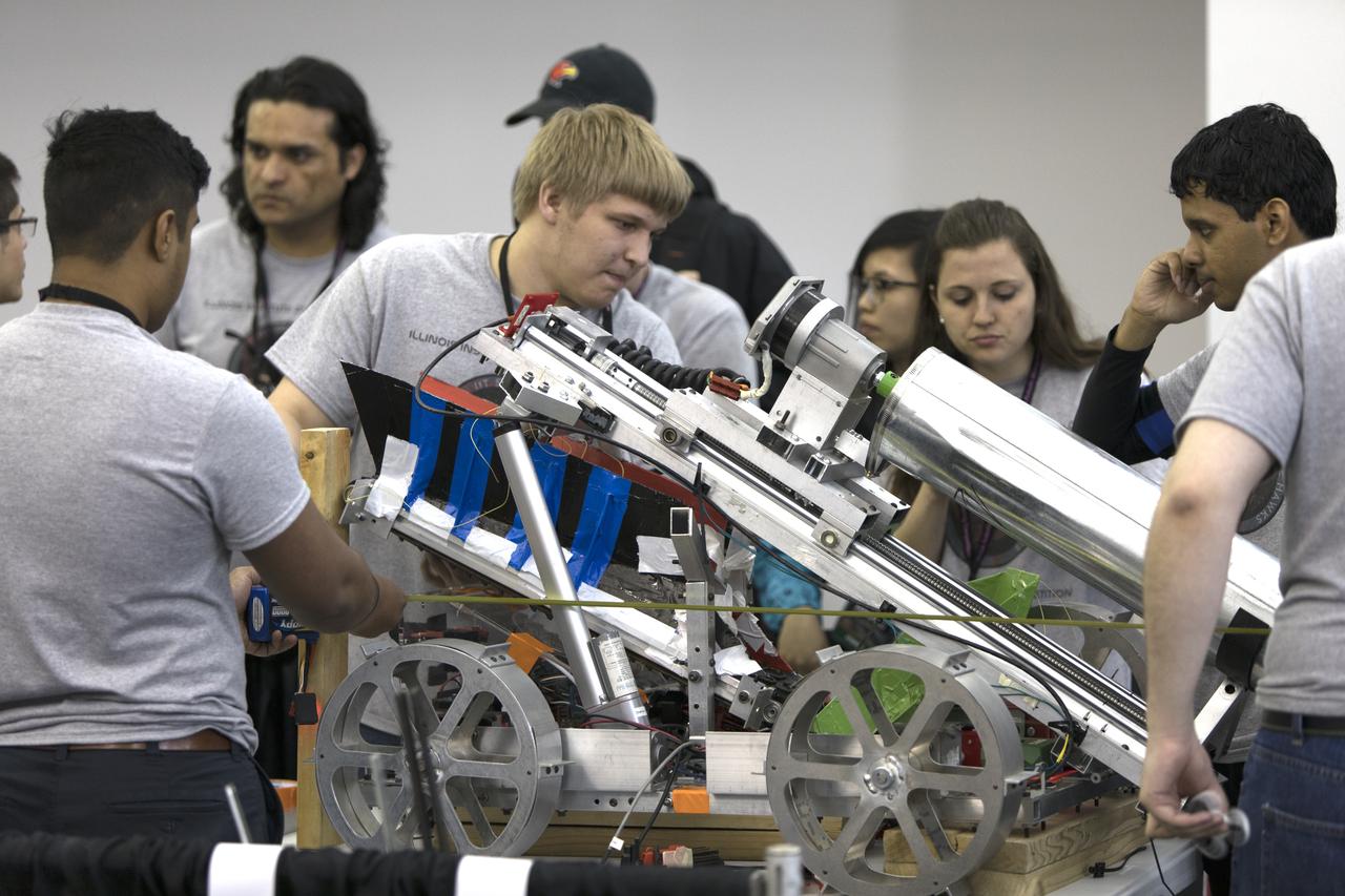On the first day of NASA's 9th Robotic Mining Competition, set-up day on May 14, team members from the Illinois Institute of Technology work on their robot miner in the RobotPits in the Educator Resource Center at Kennedy Space Center Visitor Complex in Florida. More than 40 student teams from colleges and universities around the U.S. will use their mining robots to dig in a supersized sandbox filled with BP-1, or simulated Lunar soil, gravel and rocks, and participate in other competition requirements. The Robotic Mining Competition is a NASA Human Exploration and Operations Mission Directorate project designed to encourage students in science, technology, engineering and math, or STEM fields. The project provides a competitive environment to foster innovative ideas and solutions that could be used on NASA's deep space missions.