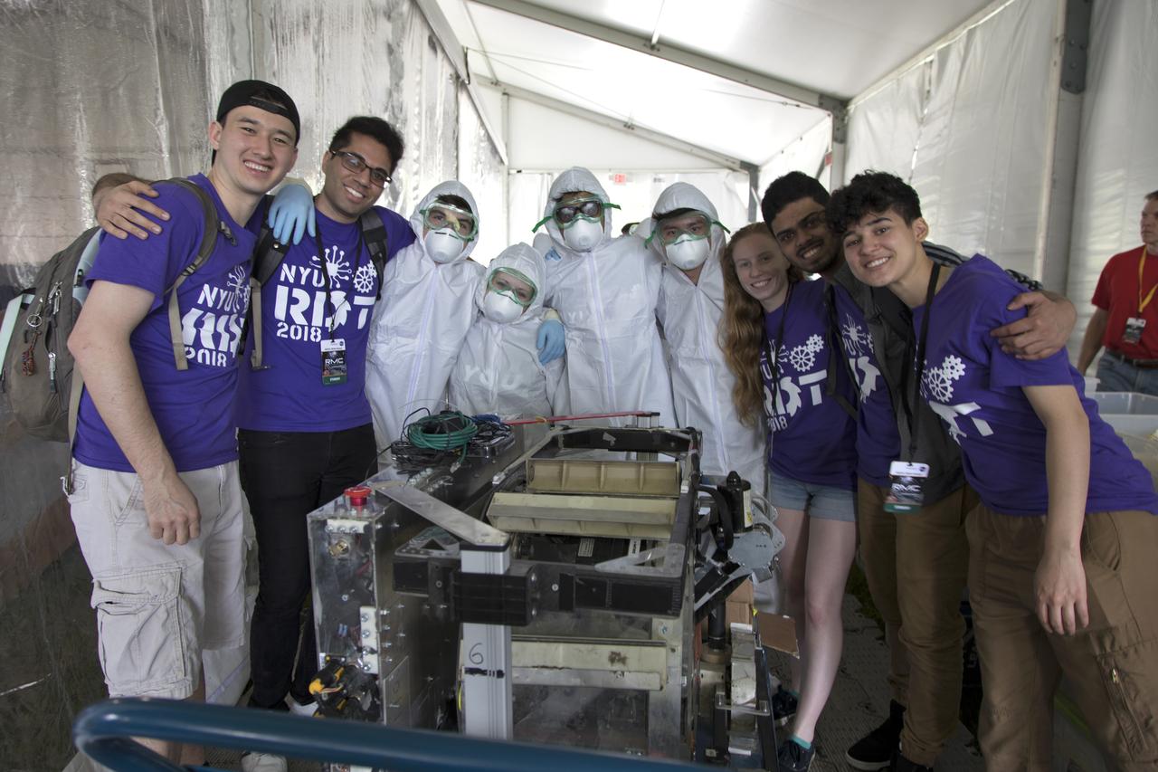 Team members from New York University prepare their robot miner for its turn in the mining arena on the third day of NASA's 9th Robotic Mining Competition, May 16, at NASA's Kennedy Space Center Visitor Complex in Florida. More than 40 student teams from colleges and universities around the U.S. will use their mining robots to dig in a supersized sandbox filled with BP-1, or simulated Lunar soil, gravel and rocks, and participate in other competition requirements. The Robotic Mining Competition is a NASA Human Exploration and Operations Mission Directorate project designed to encourage students in science, technology, engineering and math, or STEM fields. The project provides a competitive environment to foster innovative ideas and solutions that could be used on NASA's deep space missions.