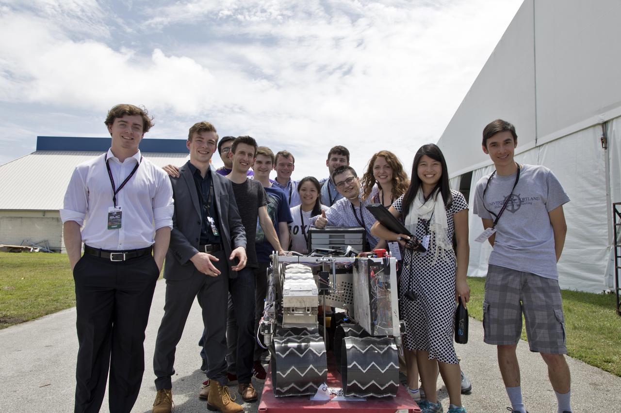 On the third day of NASA's 9th Robotic Mining Competition, May 16, team members from the University of Portland pause with their robot miner before its turn in the mining arena at NASA's Kennedy Space Center Visitor Complex in Florida. More than 40 student teams from colleges and universities around the U.S. will use their mining robots to dig in a supersized sandbox filled with BP-1, or simulated Lunar soil, gravel and rocks, and participate in other competition requirements. The Robotic Mining Competition is a NASA Human Exploration and Operations Mission Directorate project designed to encourage students in science, technology, engineering and math, or STEM fields. The project provides a competitive environment to foster innovative ideas and solutions that could be used on NASA's deep space missions.