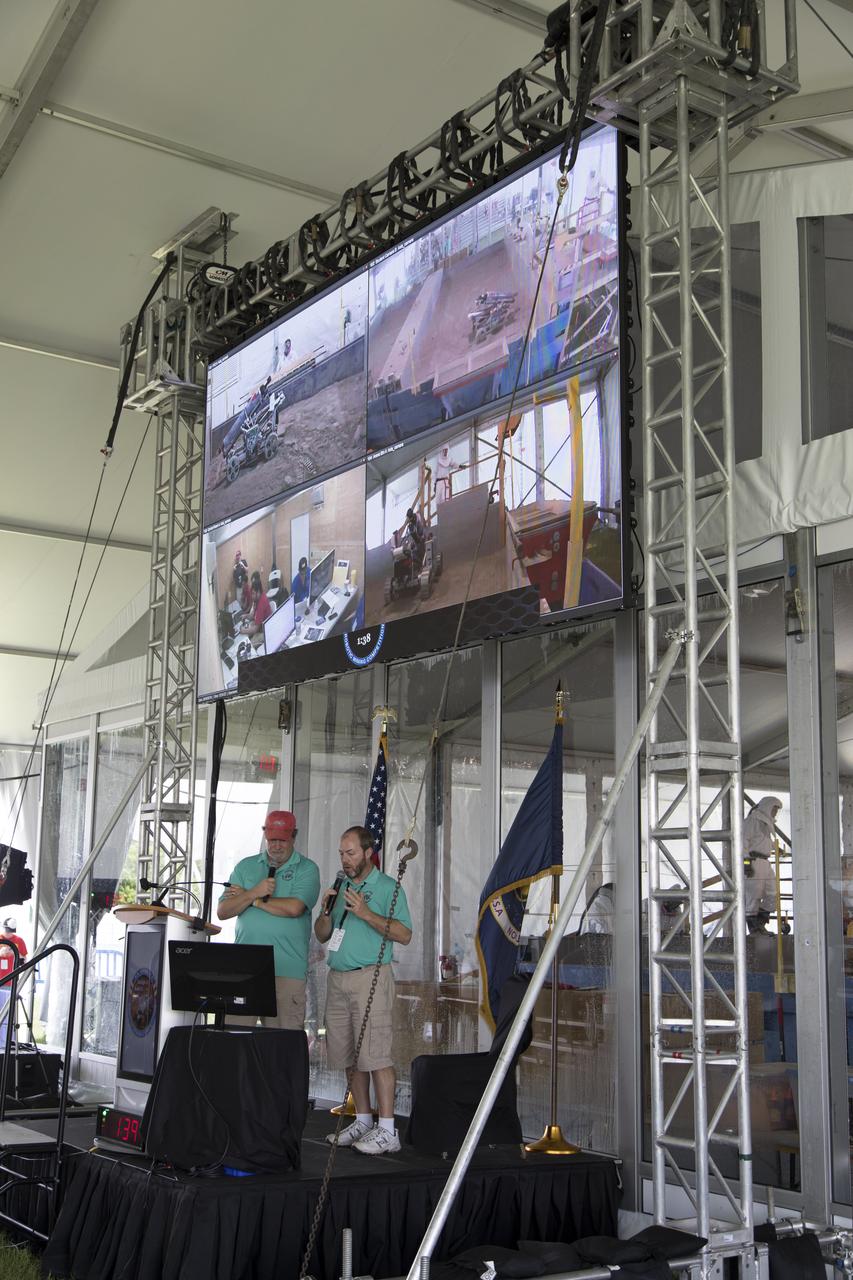During the third day of NASA's 9th Robotic Mining Competition, May 16, Al Feinberg, left, with Kennedy Space Center's Communication and Public Engagement, and Kurt Leucht, with Kennedy's Engineering Directorate, provide commentary as robot miners dig in the dirt in the mining arena at NASA's Kennedy Space Center Visitor Complex in Florida. More than 40 student teams from colleges and universities around the U.S. will use their mining robots to dig in a supersized sandbox filled with BP-1, or simulated Lunar soil, gravel and rocks, and participate in other competition requirements. The Robotic Mining Competition is a NASA Human Exploration and Operations Mission Directorate project designed to encourage students in science, technology, engineering and math, or STEM fields. The project provides a competitive environment to foster innovative ideas and solutions that could be used on NASA's deep space missions.