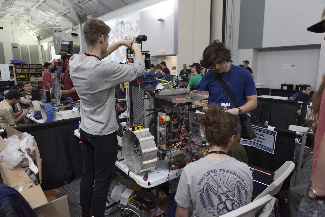 Team members from the University of Colorado Boulder work on their robot miner in the RobotPits in the Educator Resource Center on the fourth day of NASA's 9th Robotic Mining Competition, May 17, at NASA's Kennedy Space Center Visitor Complex in Florida. More than 40 student teams from colleges and universities around the U.S. are using their mining robots to dig in a supersized sandbox filled with BP-1, or simulated Lunar soil, gravel and rocks, and participate in other competition requirements. The Robotic Mining Competition is a NASA Human Exploration and Operations Mission Directorate project designed to encourage students in science, technology, engineering and math, or STEM fields. The project provides a competitive environment to foster innovative ideas and solutions that could be used on NASA's deep space missions.