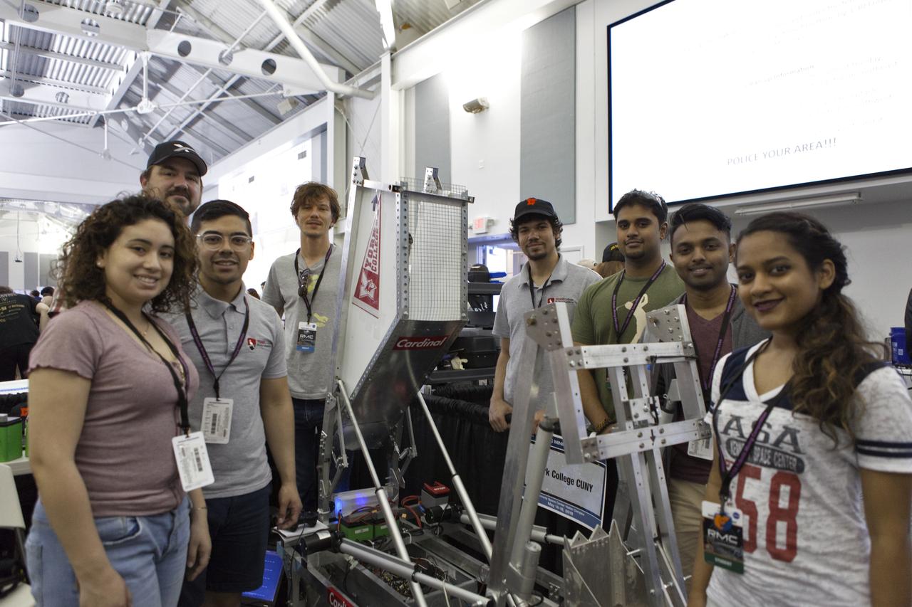 Team members from York College CUNY are with their robot miner in the RobotPits on the fourth day of NASA's 9th Robotic Mining Competition, May 17, at NASA's Kennedy Space Center Visitor Complex in Florida. More than 40 student teams from colleges and universities around the U.S. are using their mining robots to dig in a supersized sandbox filled with BP-1, or simulated Lunar soil, gravel and rocks, and participate in other competition requirements. The Robotic Mining Competition is a NASA Human Exploration and Operations Mission Directorate project designed to encourage students in science, technology, engineering and math, or STEM fields. The project provides a competitive environment to foster innovative ideas and solutions that could be used on NASA's deep space missions.