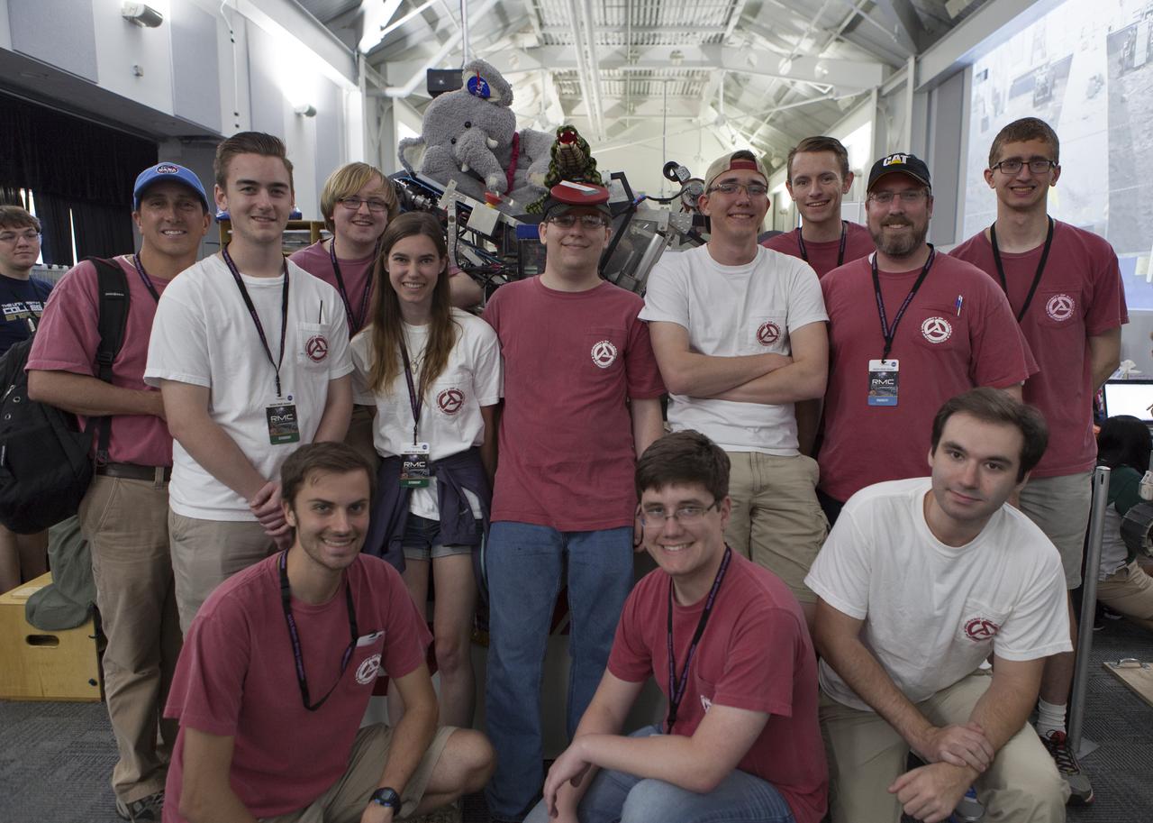 Team members from The University of Alabama pause with their robot miner in the RobotPits on the fourth day of NASA's 9th Robotic Mining Competition, May 17, at NASA's Kennedy Space Center Visitor Complex in Florida. More than 40 student teams from colleges and universities around the U.S. will use their mining robots to dig in a supersized sandbox filled with BP-1, or simulated Lunar soil, gravel and rocks, and participate in other competition requirements. The Robotic Mining Competition is a NASA Human Exploration and Operations Mission Directorate project designed to encourage students in science, technology, engineering and math, or STEM fields. The project provides a competitive environment to foster innovative ideas and solutions that could be used on NASA's deep space missions.