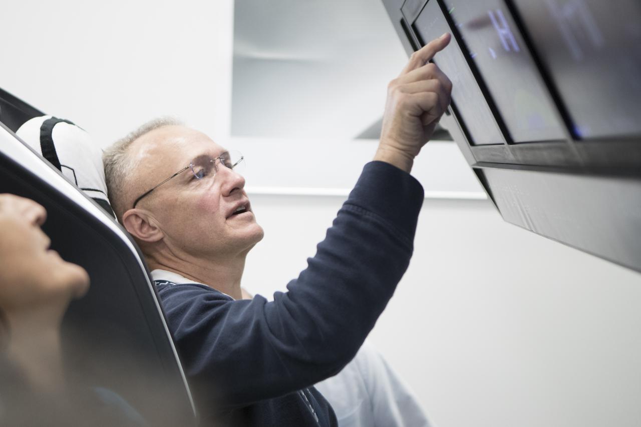 NASA Astronaut Doug Hurley interfaces with the display inside a mock-up of the Crew Dragon spacecraft in Hawthorne, California, during a testing exercise on Tuesday, April 3, 2018.