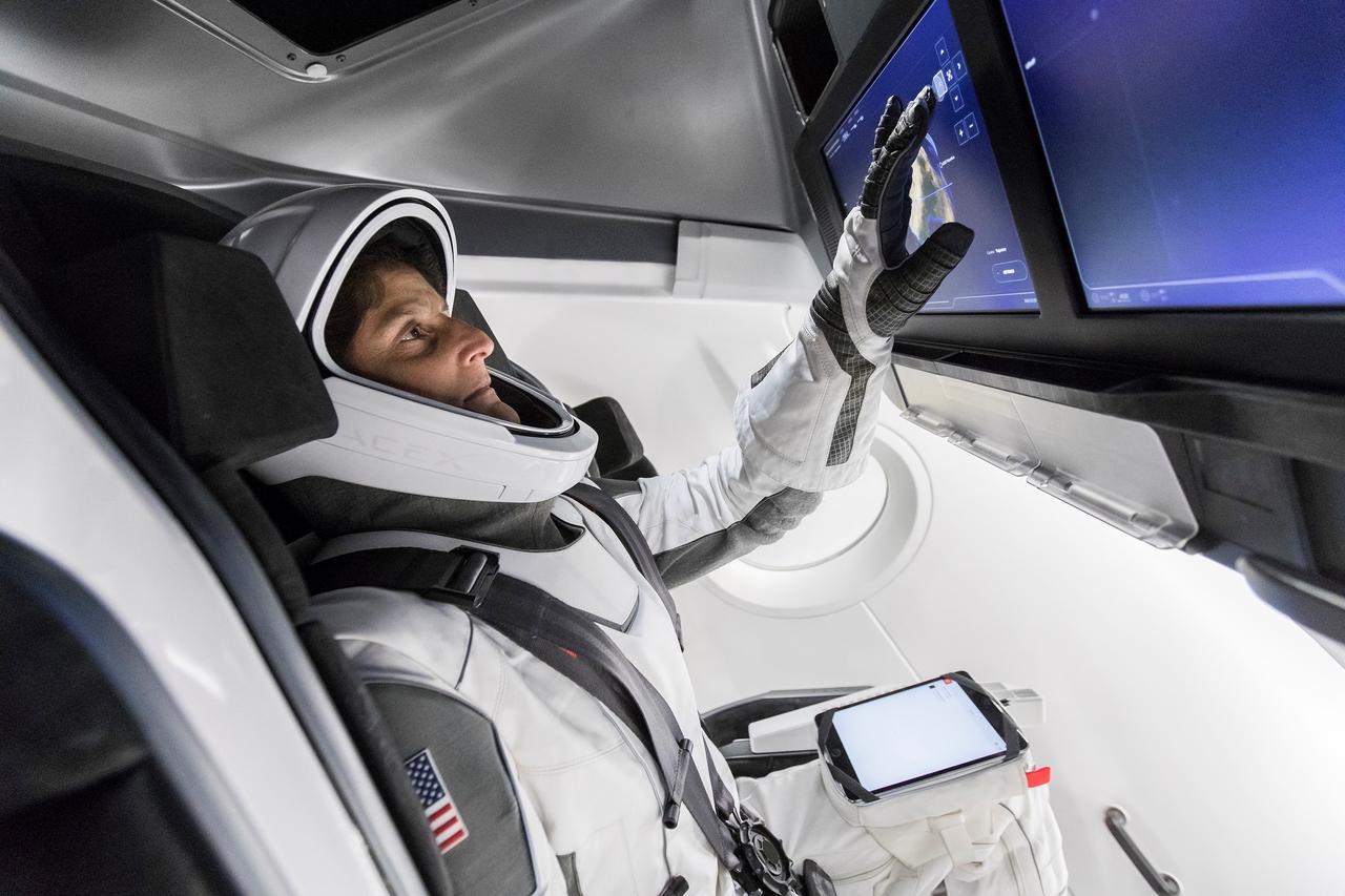NASA Astronaut Suni Williams, fully suited in SpaceX’s spacesuit, interfaces with the display inside a mock-up of the Crew Dragon spacecraft in Hawthorne, California, during a testing exercise on Tuesday, April 3, 2018. 