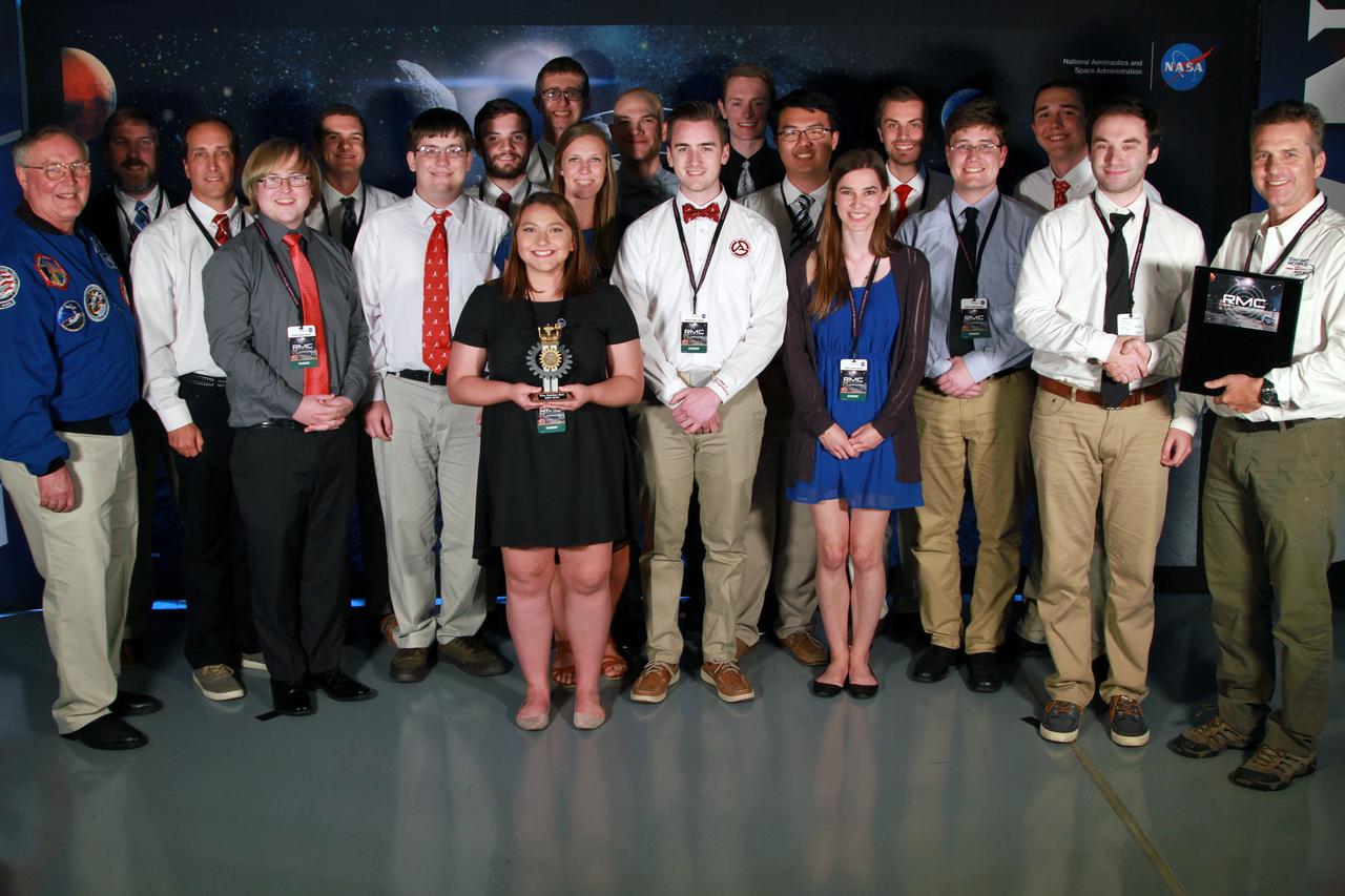 NASA's 9th Annual Robotic Mining Competition concludes with an awards ceremony May 18, 2018, at the Apollo/Saturn V Center at the Kennedy Space Center Visitor Complex in Florida. The University of Alabama Team Astrobotics received first place in the On-Site Mining Award. At left is retired NASA astronaut Jerry Ross. At right is Rob Mueller, lead mining judge. More than 40 student teams from colleges and universities around the U.S. participated in the competition, May 14-18, by using their mining robots to dig in a supersized sandbox filled with BP-1, or simulated lunar soil, gravel and rocks, and participate in other competition requirements. The Robotic Mining Competition is a NASA Human Exploration and Operations Mission Directorate project designed to encourage students in science, technology, engineering and math, or STEM fields. The project provides a competitive environment to foster innovative ideas and solutions that could be used on NASA's deep space missions.