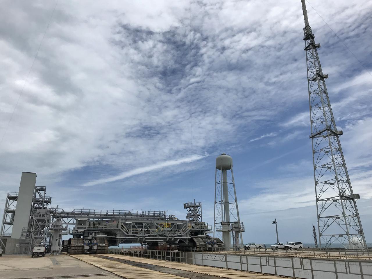 Crawler-transporter 2 (CT-2) arrives on the surface of Launch Pad 39B for a fit check on May 22, 2018, at NASA's Kennedy Space Center in Florida. The test drive to the pad confirms that all of the recent modifications to CT-2 and Pad 39B are operational to support the launch of the agency's Space Launch System rocket and Orion spacecraft on Exploration Mission-1. In view, at right, is one of three lightning protection towers positioned around Pad 39B. Exploration Ground Systems managed the modifications and upgrades to CT-2 and Pad 39B to prepare for EM-1 and deep space exploration missions.