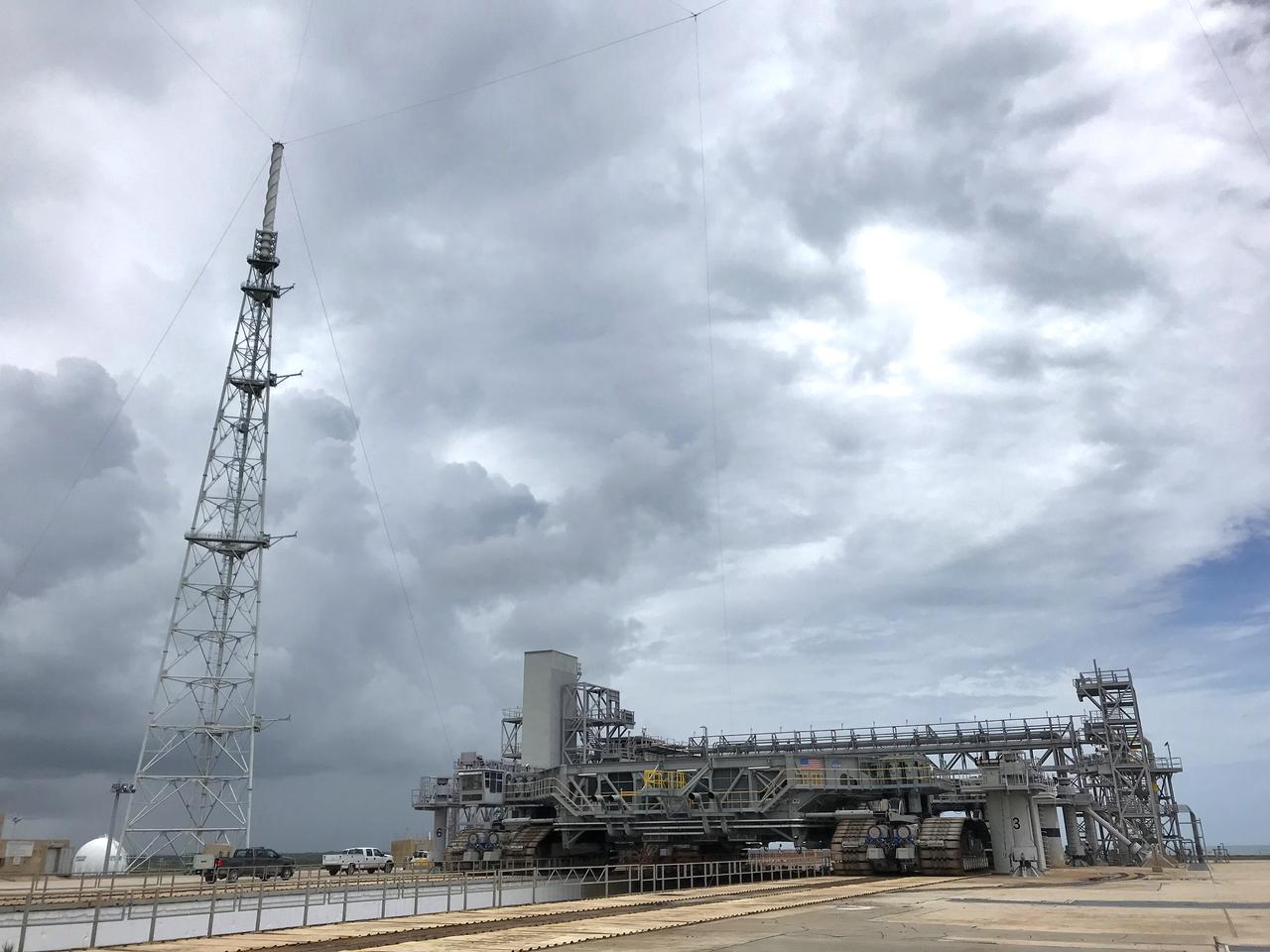 Crawler-transporter 2 (CT-2) arrives on the surface of Launch Pad 39B for a fit check on May 22, 2018, at NASA's Kennedy Space Center in Florida. The test drive to the pad confirms that all of the recent modifications to CT-2 and Pad 39B are operational to support the launch of the agency's Space Launch System rocket and Orion spacecraft on Exploration Mission-1. In view, at left, is one of three lightning protection towers positioned around Pad 39B. Exploration Ground Systems managed the modifications and upgrades to CT-2 and Pad 39B to prepare for EM-1 and deep space exploration missions.