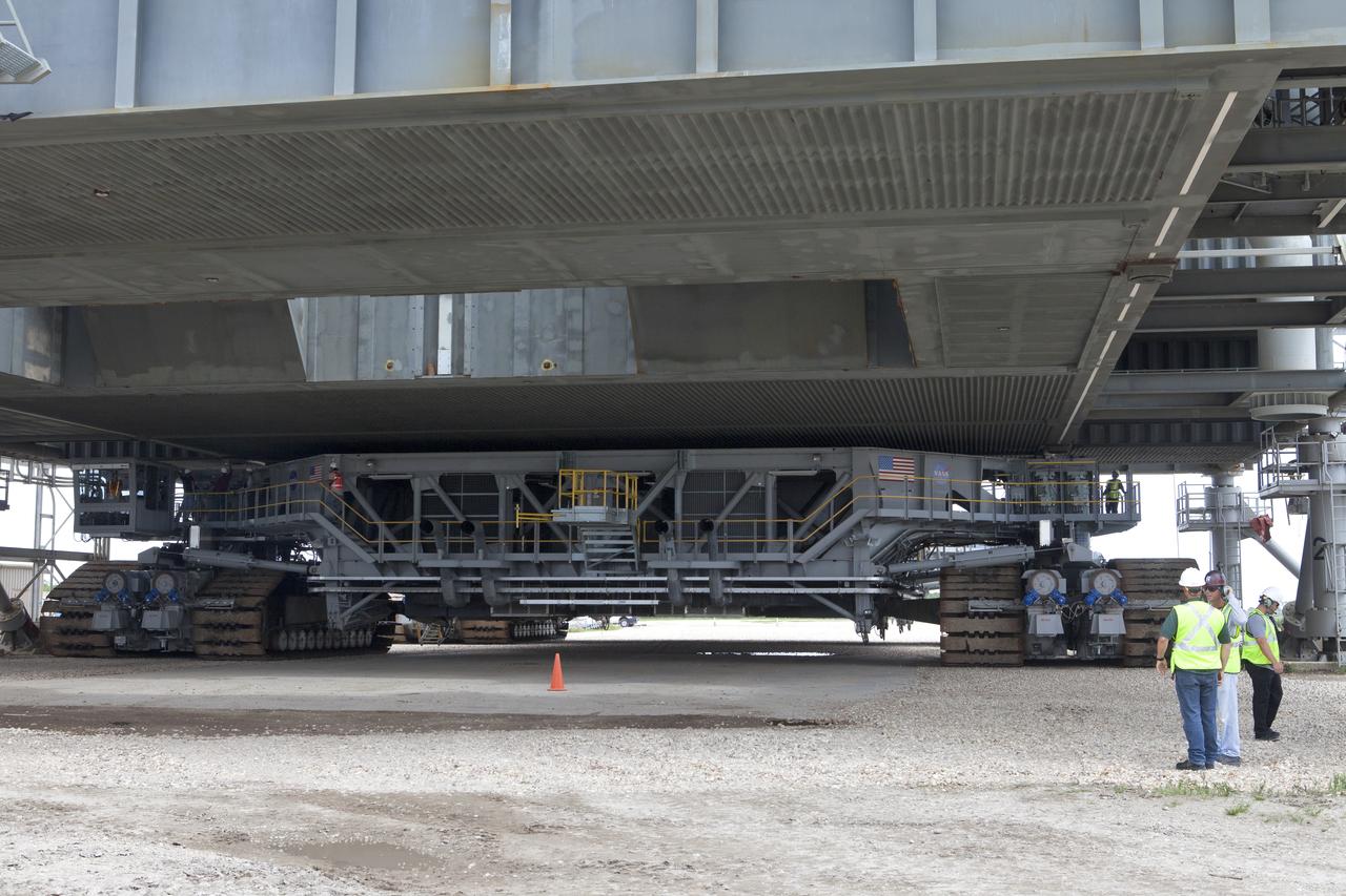 Crawler-transporter 2 (CT-2) is moved under the mobile launcher May 31, 2018, at NASA's Kennedy Space Center in Florida. Three lifts will be performed to practice lifting procedures, validate interface locations, confirm the weight of the mobile launcher, and develop a baseline for modal analysis. The mobile launcher is equipped with a number of lines, called umbilicals, which will connect to NASA's Space Launch System (SLS) and Orion. CT-2 has been upgraded to handle the weight of the mobile launcher with SLS and Orion atop. Exploration Ground Systems is preparing the ground systems necessary to support the SLS and Orion spacecraft for Exploration Mission-1 and deep space missions.