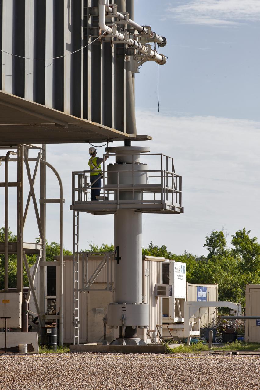 A construction worker monitors the progress as crawler-transporter 2 (CT-2) lifts the mobile launcher up a few inches from its support posts June 1, 2018, at NASA's Kennedy Space Center in Florida. Three lifts were performed to practice lifting procedures, validate interface locations, confirm the weight of the mobile launcher, and develop a baseline for modal analysis. The mobile launcher is equipped with a number of lines, called umbilicals, which will connect to NASA's Space Launch System (SLS) and Orion. The lift helped to test the capability of the upgraded CT-2 to handle the weight of the mobile launcher with SLS and Orion atop. Exploration Ground Systems is preparing the ground systems necessary to support the SLS and Orion spacecraft for Exploration Mission-1 and deep space missions.