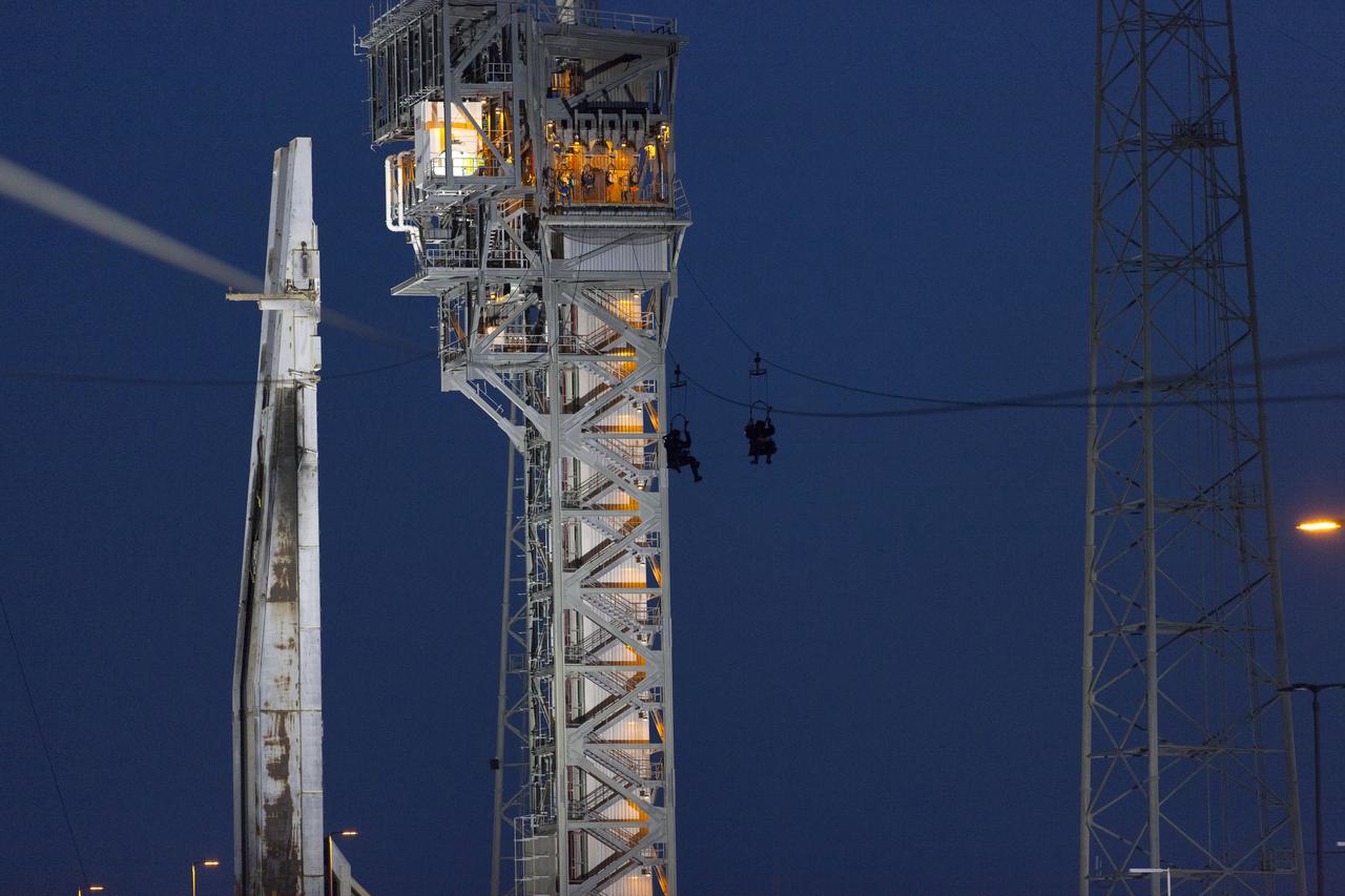 Commercial Crew astronauts participate in a Boeing/United Launch Alliance (ULA) emergency egress system demonstration at Cape Canaveral Air Force Station’s Launch Complex 41 in Florida on June 19, 2018. The emergency egress system features folding seats attached to slide wires. In the unlikely event of an emergency prior to liftoff on launch day, each person on the Crew Access Tower would get his or her own seat and slide more than 1,300 feet to a safe area.