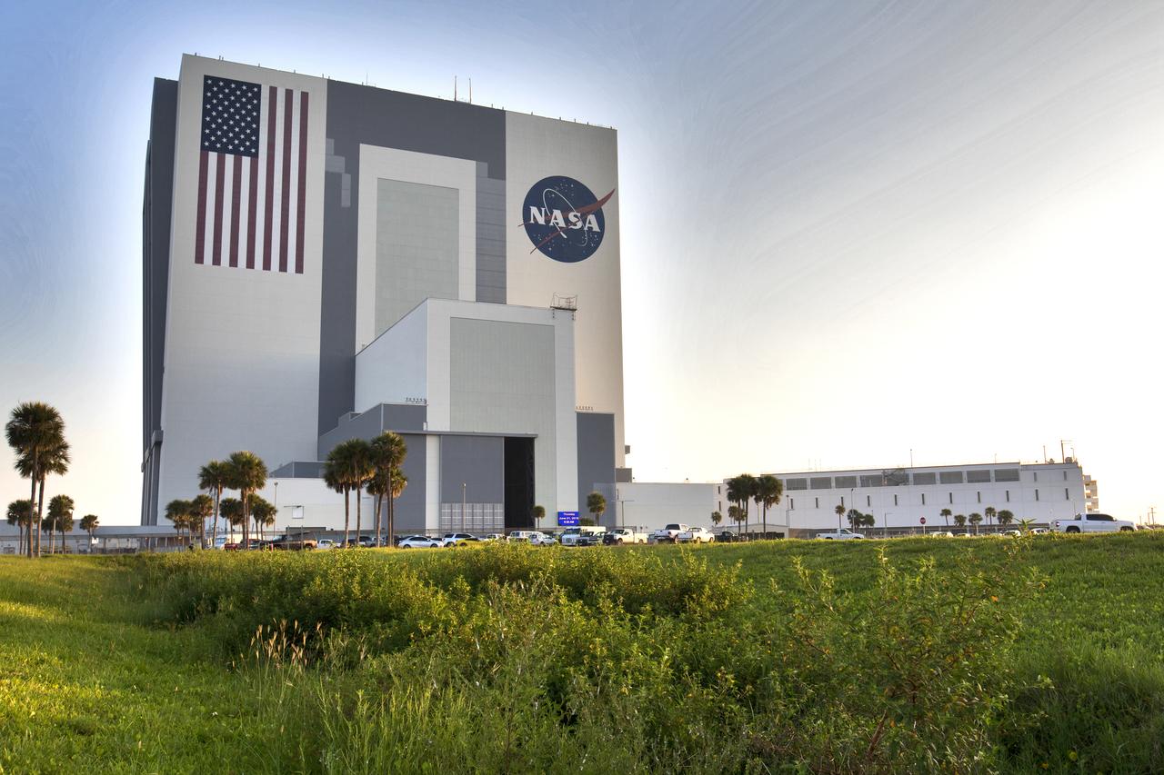 A brilliant blue sky forms the background for a panoramic view of the iconic Vehicle Assembly Building (VAB) and Launch Control Center at NASA's Kennedy Space Center in Florida. Ten levels of work platforms have been installed in High Bay 3 of the VAB. They will surround and provide access for service and processing of NASA's Space Launch System (SLS) rocket and Orion spacecraft. Exploration Ground Systems oversaw the upgrades and installation of the new work platforms to support the launch of the SLS and Orion on Exploration Mission-1 and deep space missions.