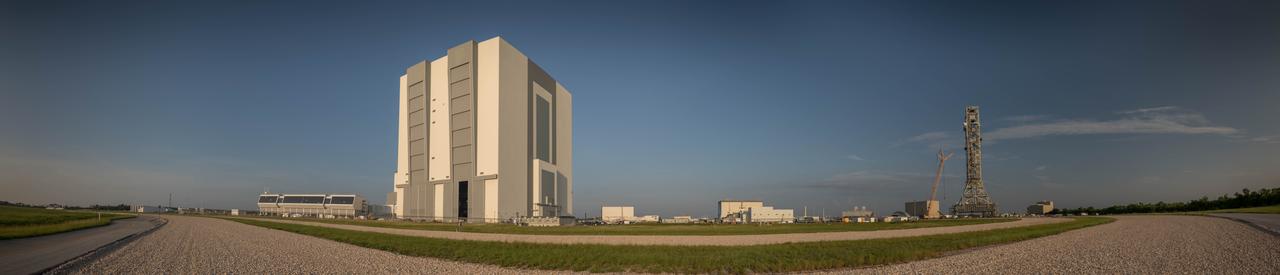 A brilliant blue sky forms the backdrop for a fish-eye panoramic view of the south side of the iconic Vehicle Assembly Building (VAB) and Launch Control Center at NASA's Kennedy Space Center in Florida. Ten levels of new work platforms have been installed in VAB High Bay 3. They will surround and provide access for service and processing of NASA's Space Launch System (SLS) rocket and Orion spacecraft. Exploration Ground Systems oversaw the upgrades and installation of the new work platforms to support the launch of the SLS and Orion on Exploration Mission-1 (EM-1) and deep space missions. At left is the Launch Control Center, where Firing Room 1 has been upgraded to support EM-1.
