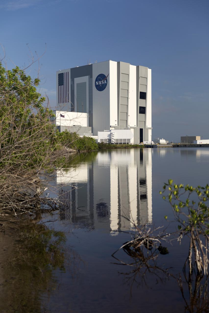 A brilliant blue sky forms the backdrop for a view of the south and east sides of the iconic Vehicle Assembly Building (VAB) at NASA's Kennedy Space Center in Florida. Exploration Ground Systems oversaw the upgrades. The building casts a reflection in a surrounding waterway. Ten levels of new work platforms have been installed in VAB High Bay 3. They will surround and provide access for service and processing of NASA's Space Launch System (SLS) rocket and Orion spacecraft. Exploration Ground Systems oversaw the upgrades and installation of the new work platforms to support the launch of the SLS and Orion on Exploration Mission-1 and deep space missions.