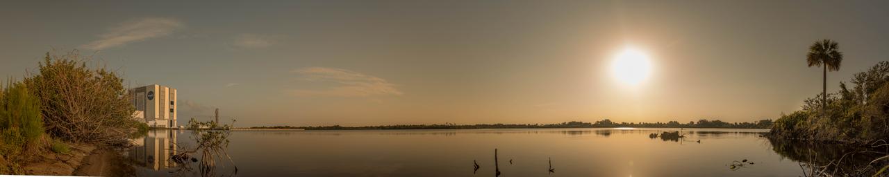 A sunrise panoramic view of the iconic Vehicle Assembly Building (VAB) and surrounding waterways at NASA's Kennedy Space Center in Florida. Ten levels of new work platforms have been installed in VAB High Bay 3. They will surround and provide access for service and processing of NASA's Space Launch System (SLS) rocket and Orion spacecraft. Exploration Ground Systems oversaw the upgrades and installation of the new work platforms to support the launch of the SLS and Orion on Exploration Mission-1 and deep space missions.