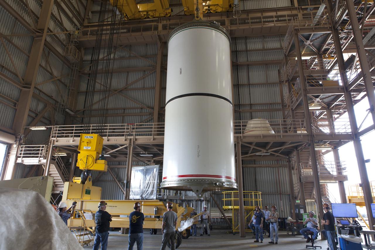 Jacobs technicians, on the Test and Operations Support Contract, practice crane operations with an inert booster rocket segment in the Rotation, Processing and Surge Facility on June 22, 2018, at NASA's Kennedy Space Center in Florida. Dual cranes are being used to move the segment from vertical to horizontal, a maneuver known as a "breakover rotation." As part of routine processing operations for the agency's Space Launch System (SLS) rocket, the RPSF team will receive all of the solid rocket fuel segments for inspection and preparation prior to transporting them to the Vehicle Assembly Building for stacking on the mobile launcher. Many pathfinding operations are being done to prepare for launch of the SLS and Orion spacecraft on Exploration Mission-1 and deep space missions.