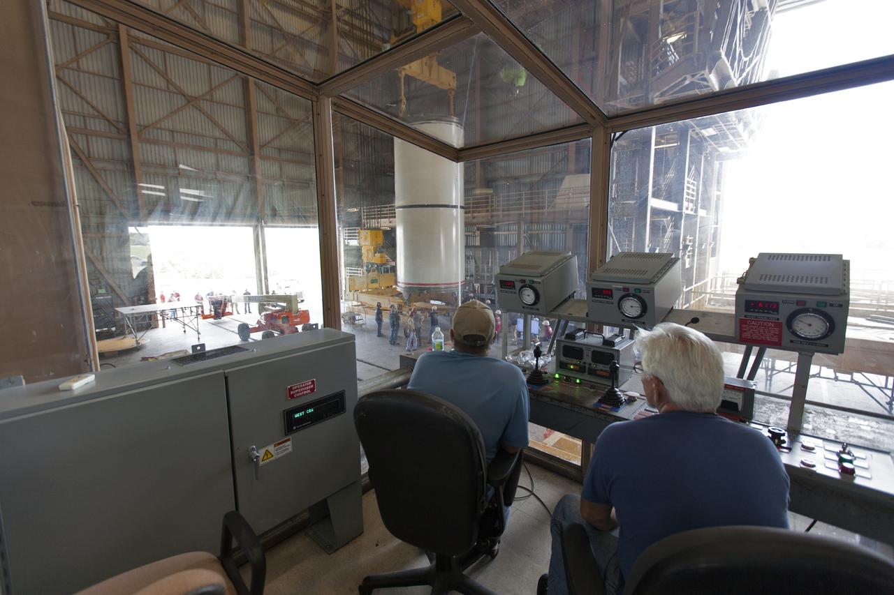 Jacobs technicians, on the Test and Operations Support Contract, practice crane operations with an inert booster rocket segment in the Rotation, Processing and Surge Facility on June 22, 2018, at NASA's Kennedy Space Center in Florida. Dual cranes are being used to move the segment from vertical to horizontal, a maneuver known as a "breakover rotation." As part of routine processing operations for the agency's Space Launch System (SLS) rocket, the RPSF team will receive all of the solid rocket fuel segments for inspection and preparation prior to transporting them to the Vehicle Assembly Building for stacking on the mobile launcher. Many pathfinding operations are being done to prepare for launch of the SLS and Orion spacecraft on Exploration Mission-1 and deep space missions.