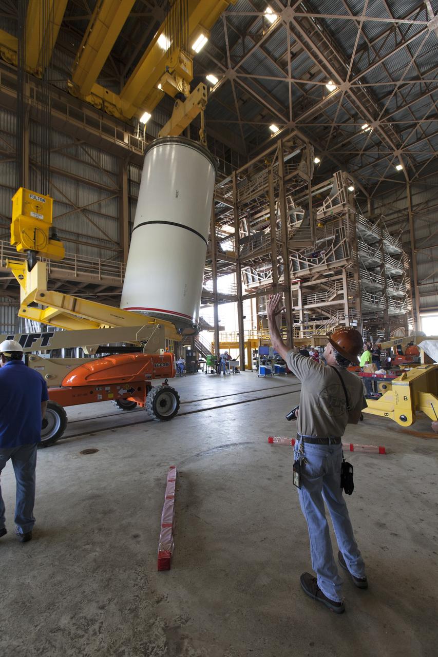 Jacobs technicians, on the Test and Operations Support Contract, practice crane operations with an inert booster rocket segment in the Rotation, Processing and Surge Facility on June 22, 2018, at NASA's Kennedy Space Center in Florida. Dual cranes are being used to move the segment from vertical to horizontal, a maneuver known as a "breakover rotation." As part of routine processing operations for the agency's Space Launch System (SLS) rocket, the RPSF team will receive all of the solid rocket fuel segments for inspection and preparation prior to transporting them to the Vehicle Assembly Building for stacking on the mobile launcher. Many pathfinding operations are being done to prepare for launch of the SLS and Orion spacecraft on Exploration Mission-1 and deep space missions.