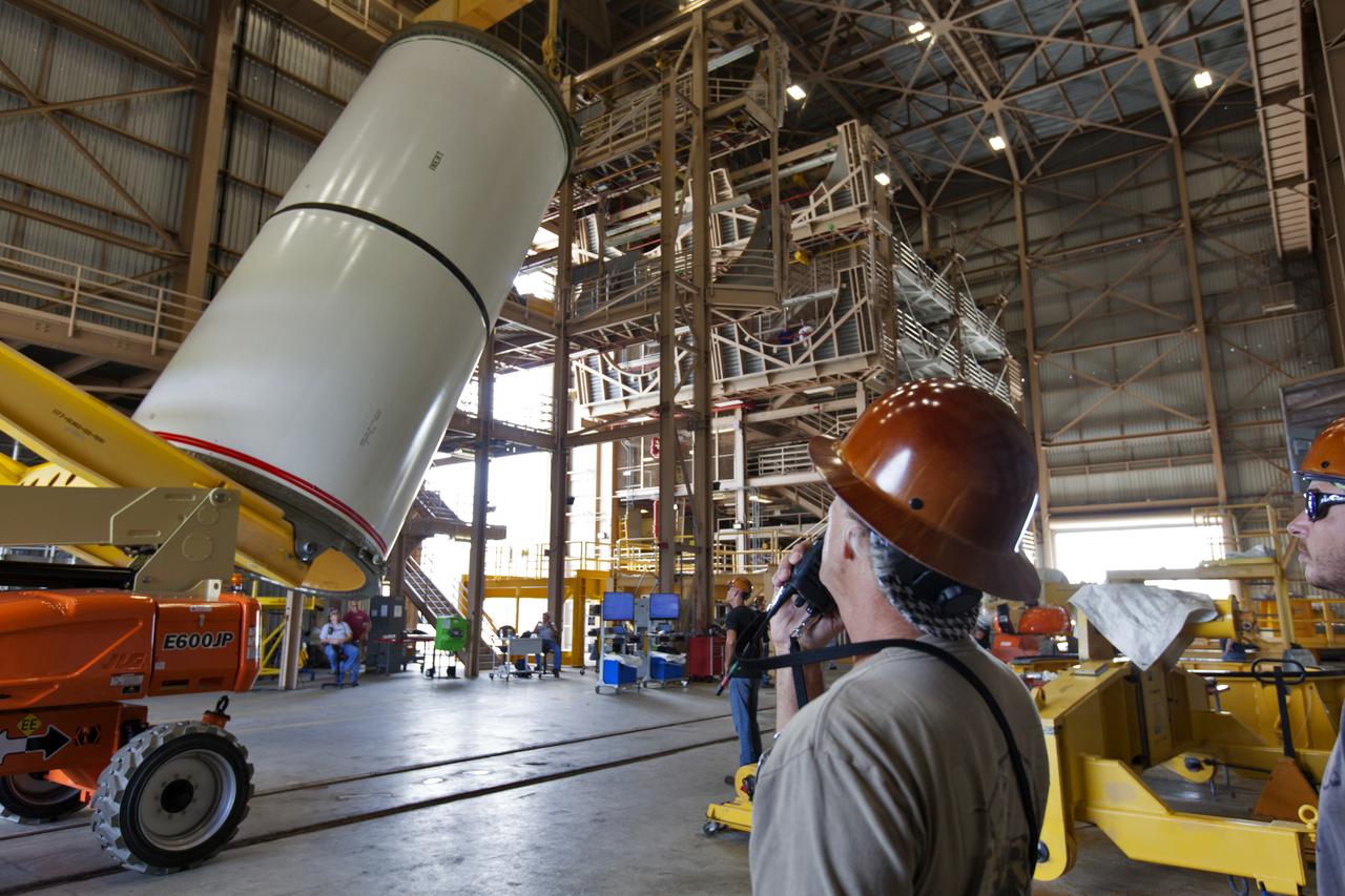 Jacobs technicians, on the Test and Operations Support Contract, practice crane operations with an inert booster rocket segment in the Rotation, Processing and Surge Facility on June 22, 2018, at NASA's Kennedy Space Center in Florida. Dual cranes are being used to move the segment from vertical to horizontal, a maneuver known as a "breakover rotation." As part of routine processing operations for the agency's Space Launch System (SLS) rocket, the RPSF team will receive all of the solid rocket fuel segments for inspection and preparation prior to transporting them to the Vehicle Assembly Building for stacking on the mobile launcher. Many pathfinding operations are being done to prepare for launch of the SLS and Orion spacecraft on Exploration Mission-1 and deep space missions.