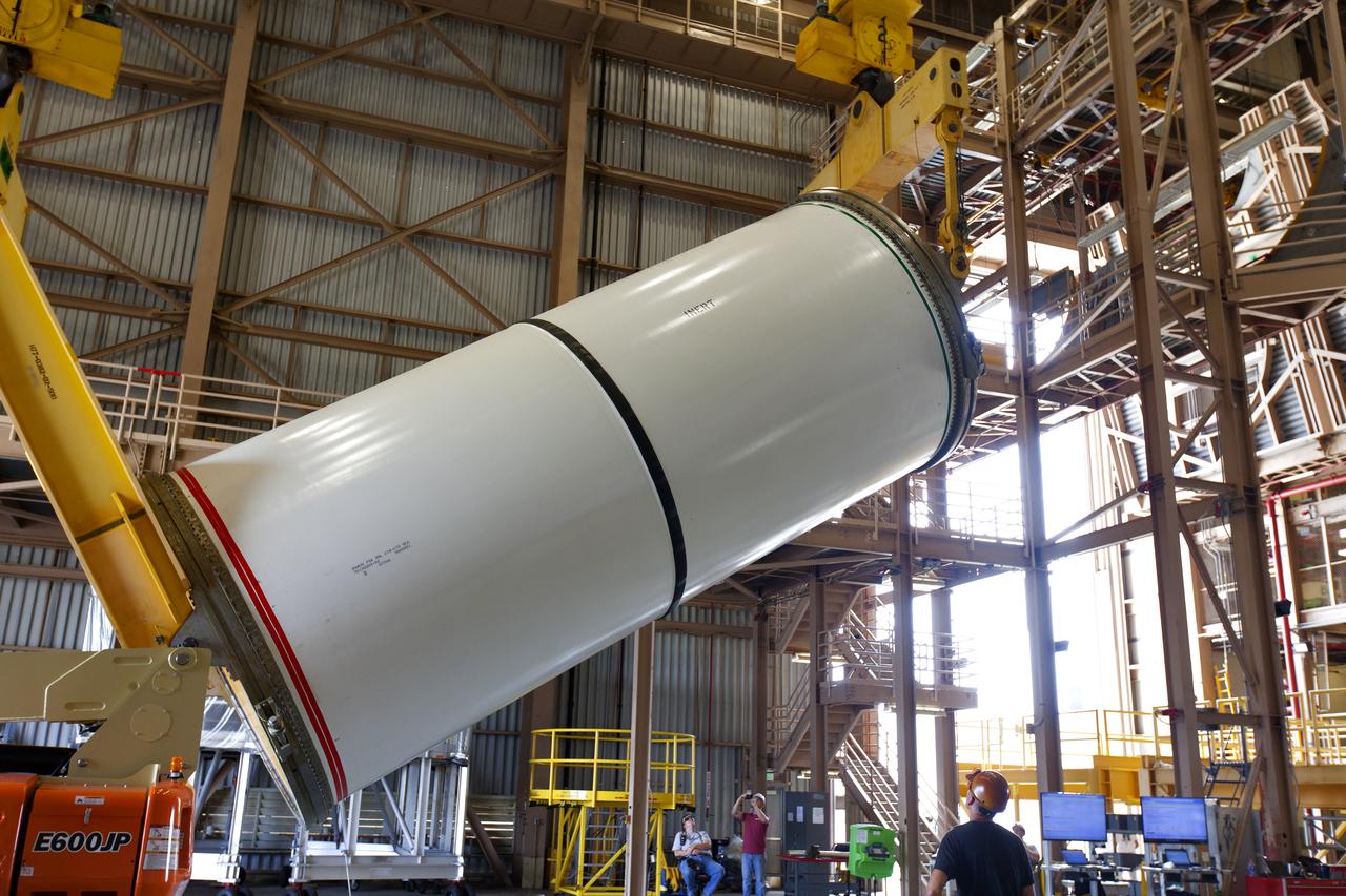 Jacobs technicians, on the Test and Operations Support Contract, practice crane operations with an inert booster rocket segment in the Rotation, Processing and Surge Facility on June 22, 2018, at NASA's Kennedy Space Center in Florida. Dual cranes are used to move the segment from vertical to horizontal, a maneuver known as a "breakover rotation." As part of routine processing operations for the agency's Space Launch System (SLS) rocket, the RPSF team will receive all of the solid rocket fuel segments for inspection and preparation prior to transporting them to the Vehicle Assembly Building for stacking on the mobile launcher. Many pathfinding operations are being done to prepare for launch of the SLS and Orion spacecraft on Exploration Mission-1 and deep space missions.