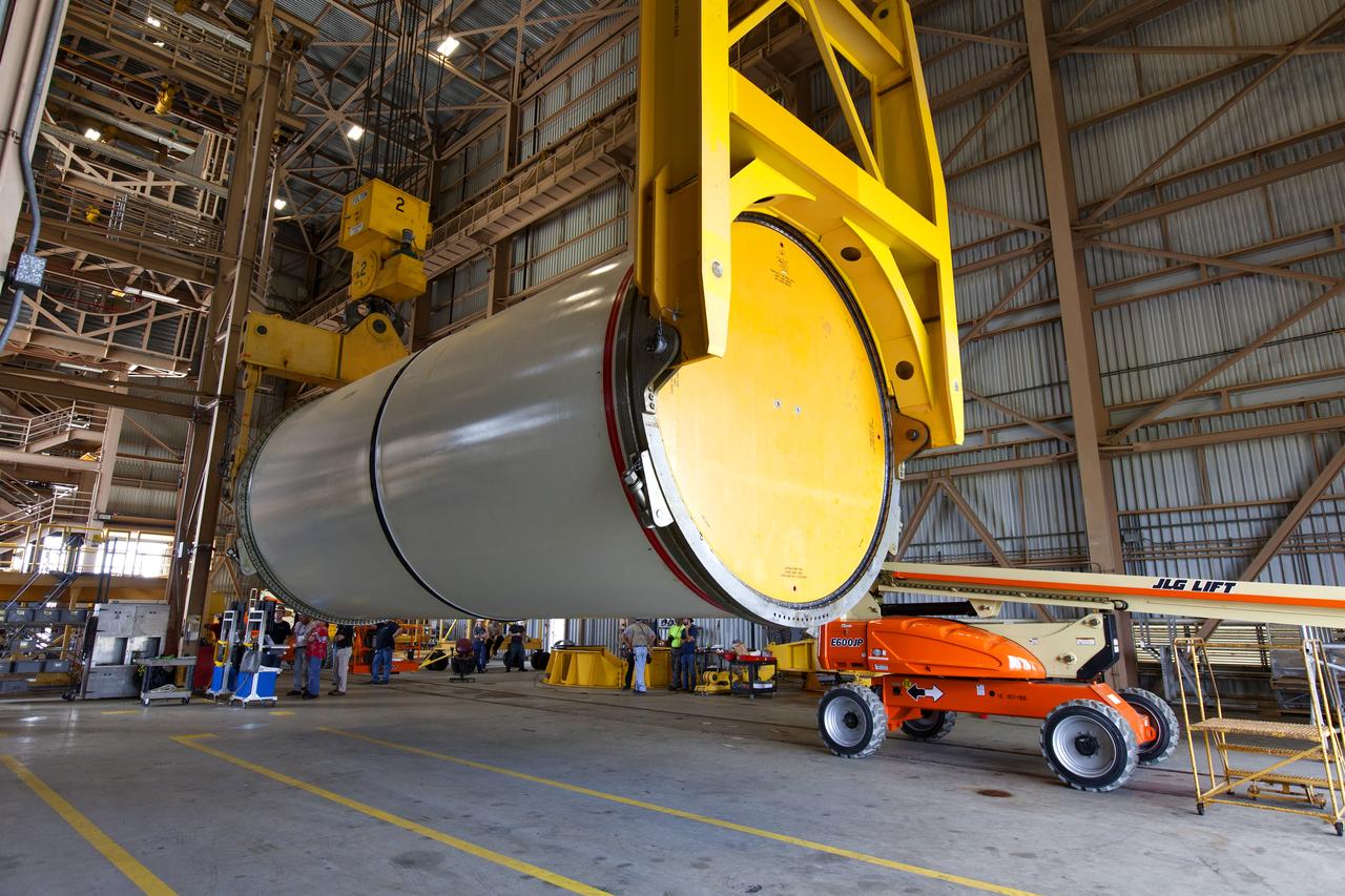 Jacobs technicians, on the Test and Operations Support Contract, practice crane operations with an inert booster rocket segment in the Rotation, Processing and Surge Facility on June 22, 2018, at NASA's Kennedy Space Center in Florida. Dual cranes were used to move the segment from vertical to horizontal, a maneuver known as a "breakover rotation." As part of routine processing operations for the agency's Space Launch System (SLS) rocket, the RPSF team will receive all of the solid rocket fuel segments for inspection and preparation prior to transporting them to the Vehicle Assembly Building for stacking on the mobile launcher. Many pathfinding operations are being done to prepare for launch of the SLS and Orion spacecraft on Exploration Mission-1 and deep space missions.