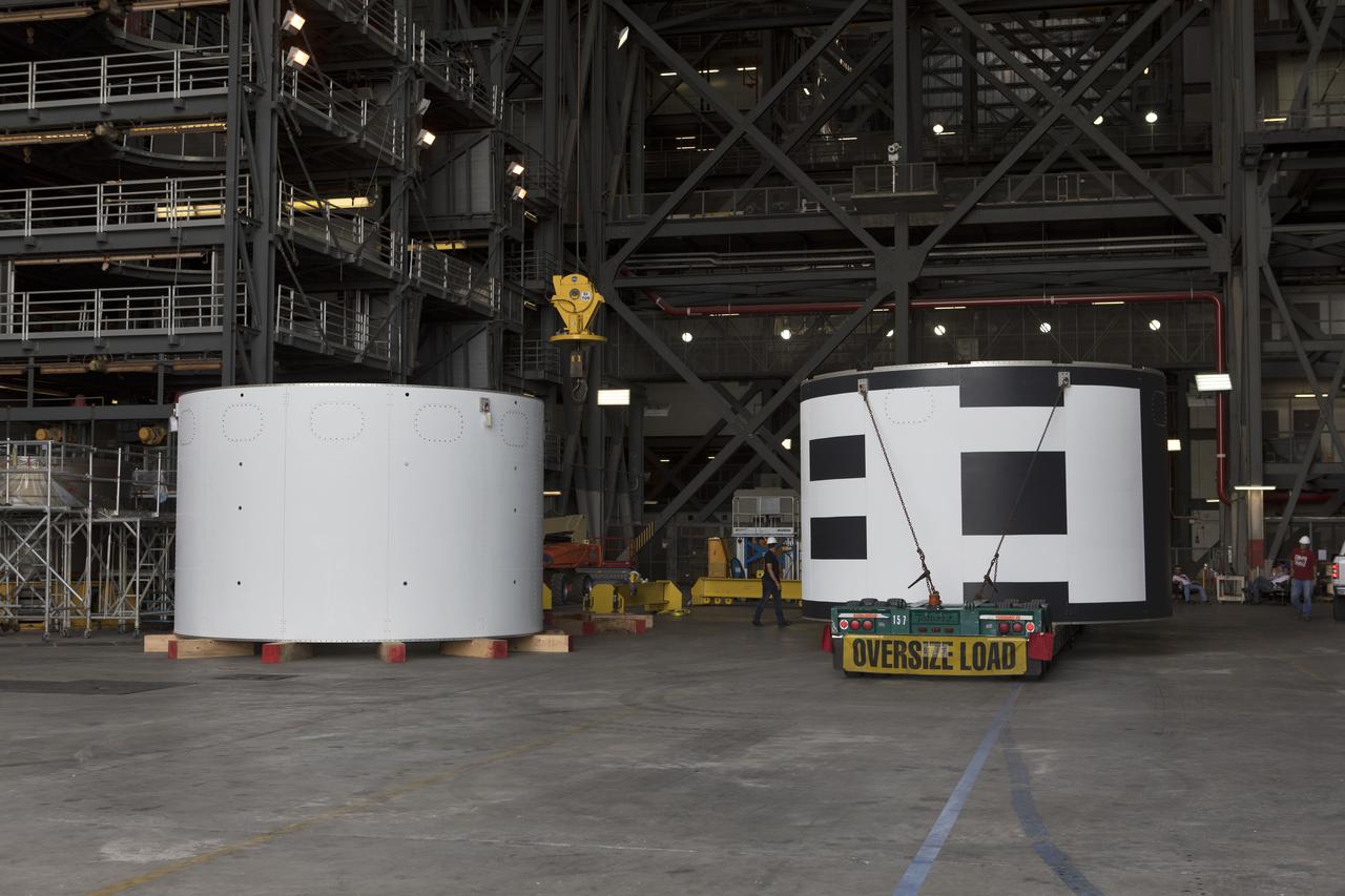 The second of three aeroshells, at right, for Orion's Launch Abort System (LAS) arrives by flatbed truck in High Bay 4 of the Vehicle Assembly Building at NASA's Kennedy Space Center in Florida, on June 26, 2018. The aeroshell was shipped from EMF Inc. on nearby Merritt Island. It will be offloaded and secured in the high bay. The aeroshells will be stacked and prepared for a full-stress test of the LAS, called Ascent Abort-2 (AA-2) flight test, scheduled for April 2019. During the test, a booster will launch from Space Launch Complex 46 at Cape Canaveral Air Force Station, carrying a fully functional LAS and a 22,000-pound Orion test vehicle to an altitude of 31,000 feet and traveling at more than 1,000 miles an hour. The test will verify the LAS can steer the crew module and astronauts aboard to safety in the event of an issue with the Space Launch System (SLS) rocket when the spacecraft is under the highest aerodynamic loads it will experience during a rapid climb into space. Orion is being prepared for its first integrated uncrewed flight atop the SLS on Exploration Mission-1.