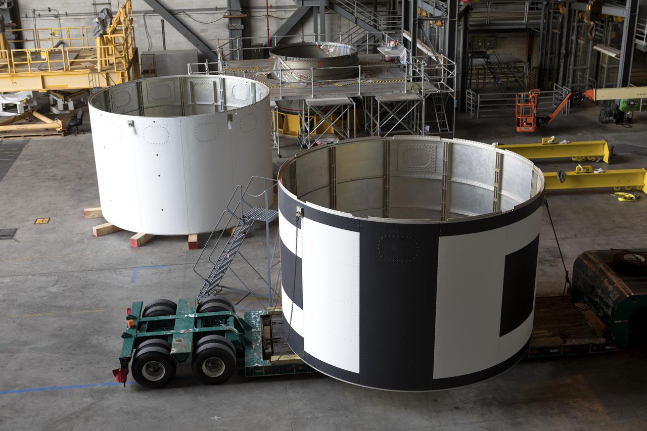 The second of three aeroshells, at right, for Orion's Launch Abort System (LAS) arrives by flatbed truck in High Bay 4 of the Vehicle Assembly Building at NASA's Kennedy Space Center in Florida, on June 26, 2018. The aeroshell was shipped from EMF Inc. on nearby Merritt Island. It will be offloaded and secured in the high bay. The aeroshells will be stacked and prepared for a full-stress test of the LAS, called Ascent Abort-2 (AA-2) flight test, scheduled for April 2019. During the test, a booster will launch from Space Launch Complex 46 at Cape Canaveral Air Force Station, carrying a fully functional LAS and a 22,000-pound Orion test vehicle to an altitude of 31,000 feet and traveling at more than 1,000 miles an hour. The test will verify the LAS can steer the crew module and astronauts aboard to safety in the event of an issue with the Space Launch System (SLS) rocket when the spacecraft is under the highest aerodynamic loads it will experience during a rapid climb into space. Orion is being prepared for its first integrated uncrewed flight atop the SLS on Exploration Mission-1.