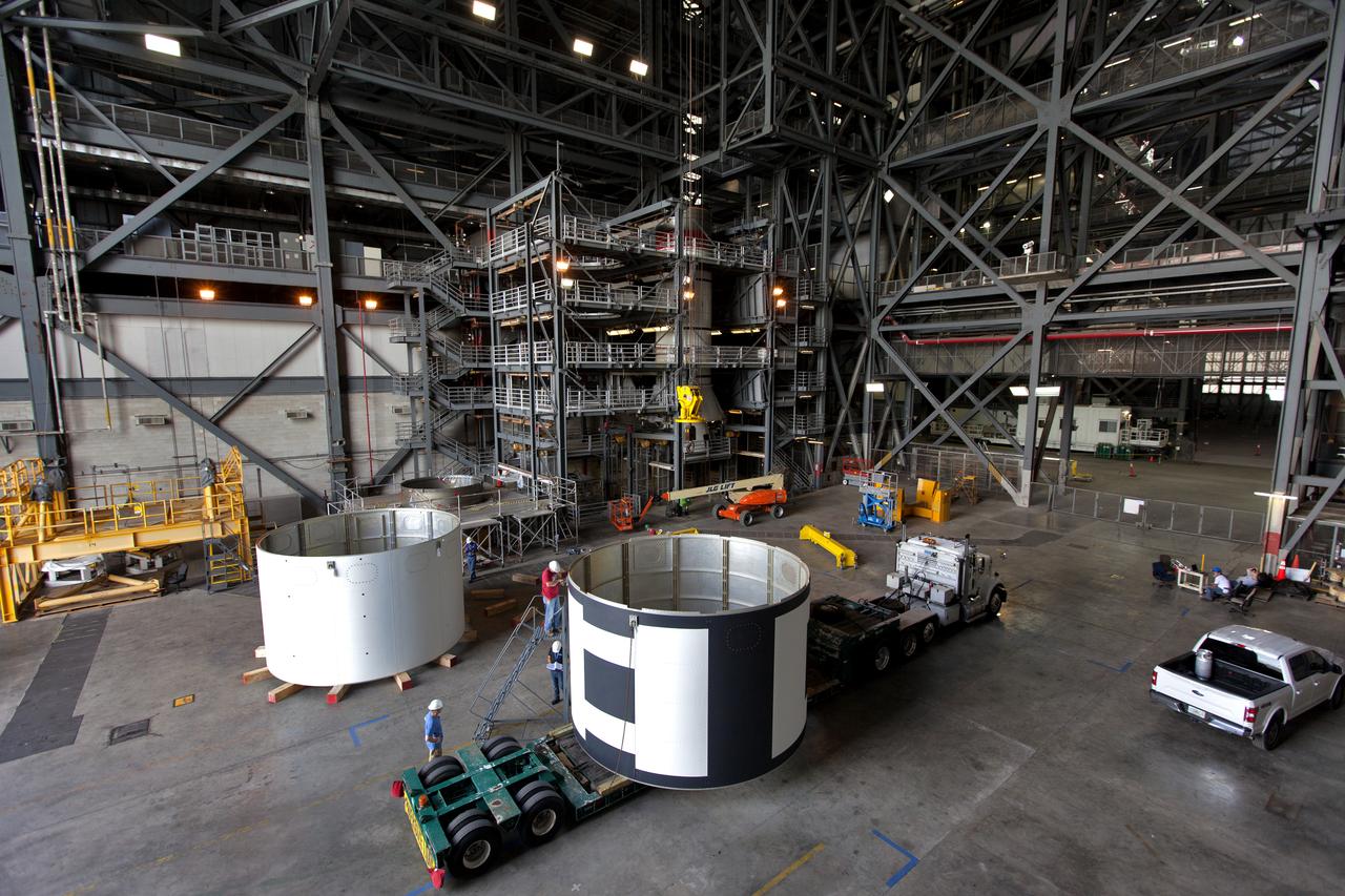 The second of three aeroshells, at right, for Orion's Launch Abort System (LAS) arrives by flatbed truck in High Bay 4 of the Vehicle Assembly Building at NASA's Kennedy Space Center in Florida, on June 26, 2018. The aeroshell was shipped from EMF Inc. on nearby Merritt Island. It will be offloaded and secured in the high bay. The aeroshells will be stacked and prepared for a full-stress test of the LAS, called Ascent Abort-2 (AA-2) flight test, scheduled for April 2019. During the test, a booster will launch from Space Launch Complex 46 at Cape Canaveral Air Force Station, carrying a fully functional LAS and a 22,000-pound Orion test vehicle to an altitude of 31,000 feet and traveling at more than 1,000 miles an hour. The test will verify the LAS can steer the crew module and astronauts aboard to safety in the event of an issue with the Space Launch System (SLS) rocket when the spacecraft is under the highest aerodynamic loads it will experience during a rapid climb into space. Orion is being prepared for its first integrated uncrewed flight atop the SLS on Exploration Mission-1.