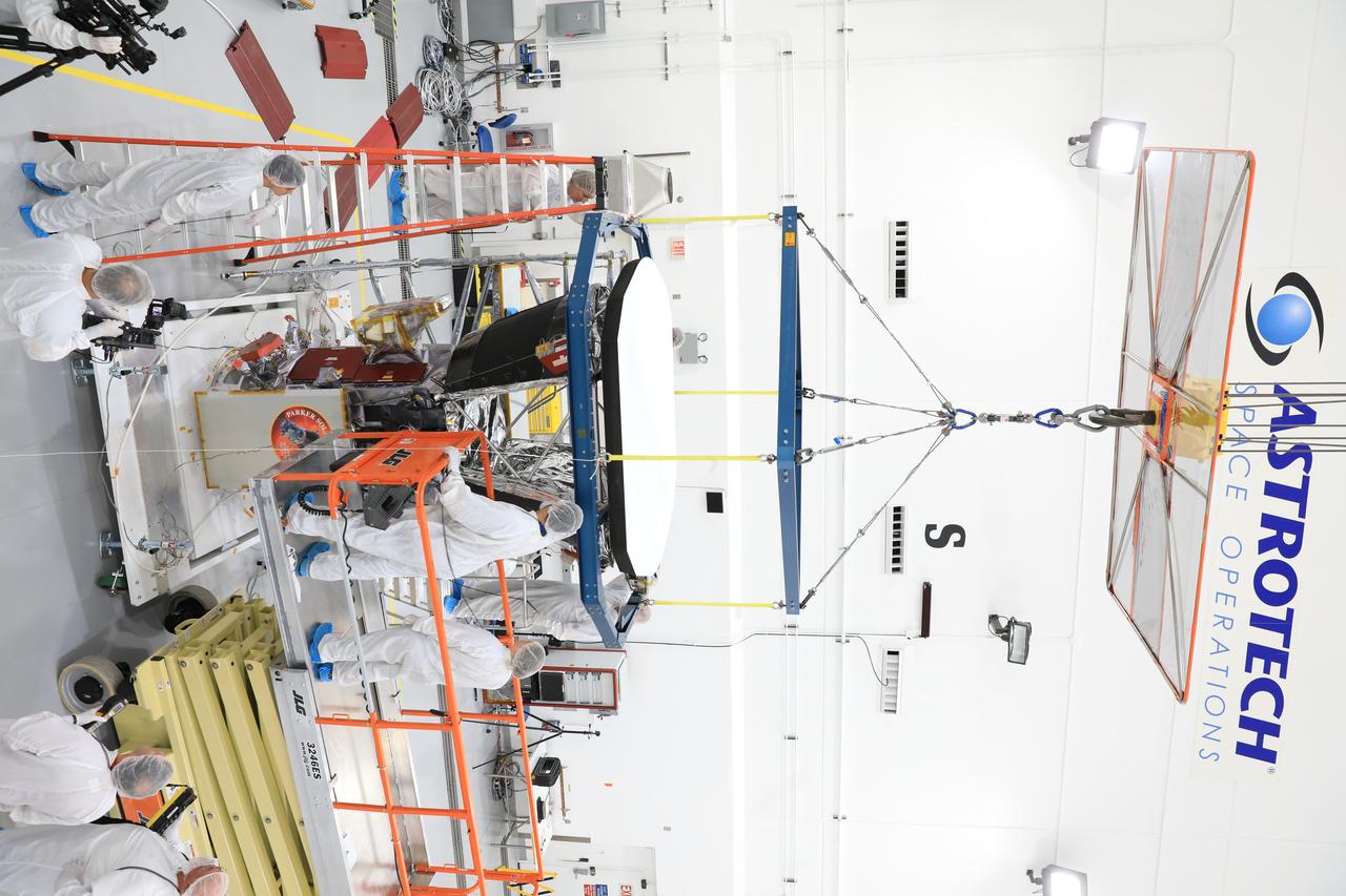 In the Astrotech processing facility in Titusville, Florida, near NASA's Kennedy Space Center, on Wednesday, June 27, 2018, technicians and engineers use a crane to install the heat shield on NASA's Parker Solar Probe. The Parker Solar Probe will launch on a United Launch Alliance Delta IV Heavy rocket from Space Launch Complex 37 at Cape Canaveral Air Force Station in Florida no earlier than Aug. 4, 2018. The mission will perform the closest-ever observations of a star when it travels through the Sun's atmosphere, called the corona. The probe will rely on measurements and imaging to revolutionize our understanding of the corona and the Sun-Earth connection.