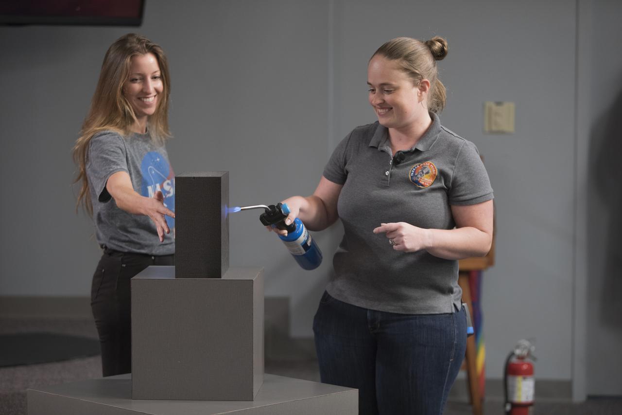 In the Kennedy Space Center’s Press Site auditorium, on Friday, July 20, 2018, Betsy Congdon, Thermal Protection System engineer with the Johns Hopkins University Applied Physics Laboratory, right, demonstrates the ability of the Parker Solar Probe's heat shield to protect the spacecraft. The presentation for the media took place during a prelaunch mission briefing for the Parker Solar Probe mission. The Parker Solar Probe will lift off on a United Launch Alliance Delta IV Heavy rocket from Space Launch Complex 37 at Cape Canaveral Air Force Station in Florida. The spacecraft was built by Applied Physics Laboratory of Johns Hopkins University in Laurel in Maryland. The mission will perform the closest-ever observations of a star when it travels through the Sun's atmosphere, called the corona. The probe will rely on measurements and imaging to revolutionize understanding of the corona and the Sun-Earth connection.