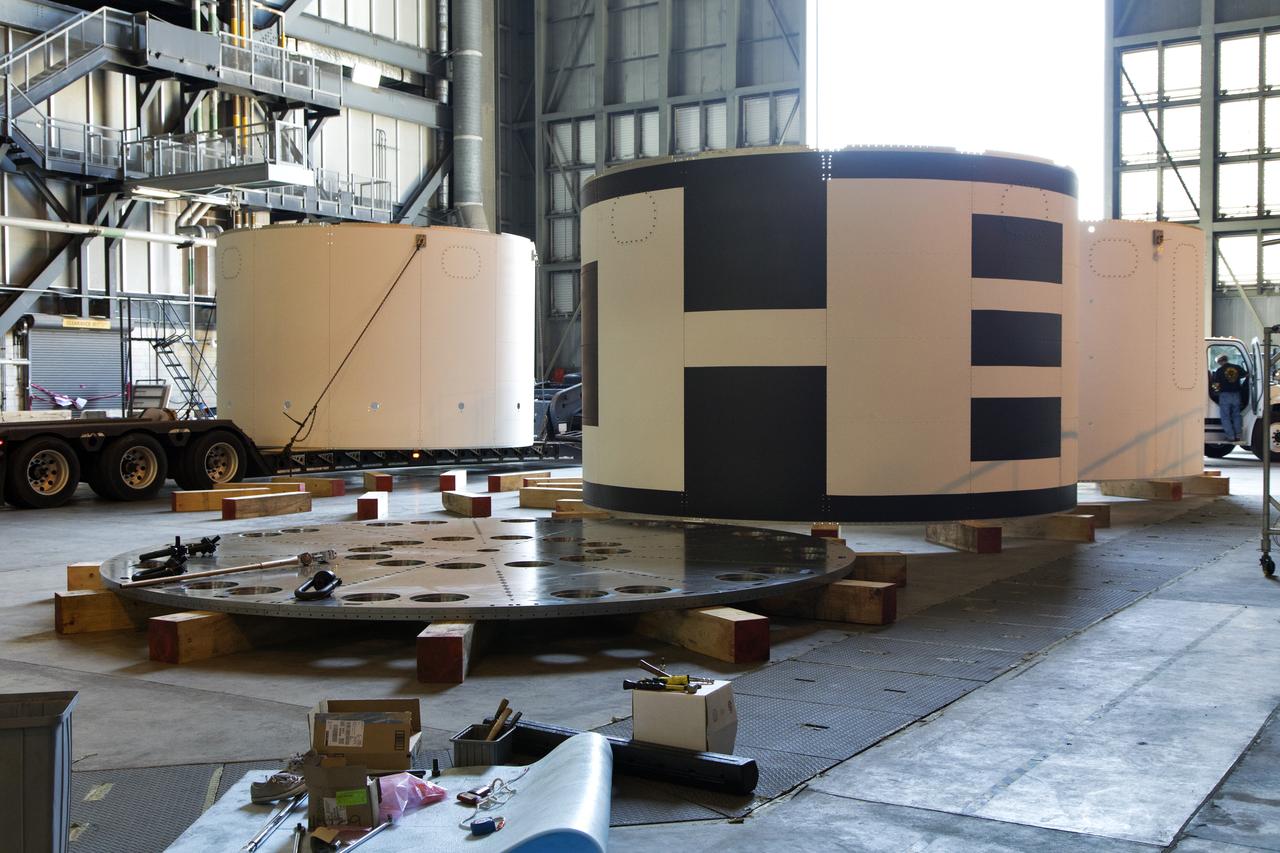 The third and final aeroshell, at left, for Orion's Launch Abort System (LAS) arrives by flatbed truck in High Bay 4 of the Vehicle Assembly Building on July 12, 2018, at NASA's Kennedy Space Center in Florida. The aeroshell was shipped from EMF Inc. on nearby Merritt Island. It will be offloaded and secured in the high bay. The aeroshells will be stacked and prepared for a full-stress test of the LAS, called Ascent Abort-2 (AA-2) flight test, scheduled for April 2019. During the test, a booster will launch from Space Launch Complex 46 at Cape Canaveral Air Force Station, carrying a fully functional LAS and a 22,000-pound Orion test vehicle to an altitude of 31,000 feet and traveling at more than 1,000 miles an hour. The test will verify the LAS can steer the crew module and astronauts aboard to safety in the event of an issue with the Space Launch System (SLS) rocket when the spacecraft is under the highest aerodynamic loads it will experience during a rapid climb into space. Orion is being prepared for its first integrated uncrewed flight atop the SLS on Exploration Mission-1.