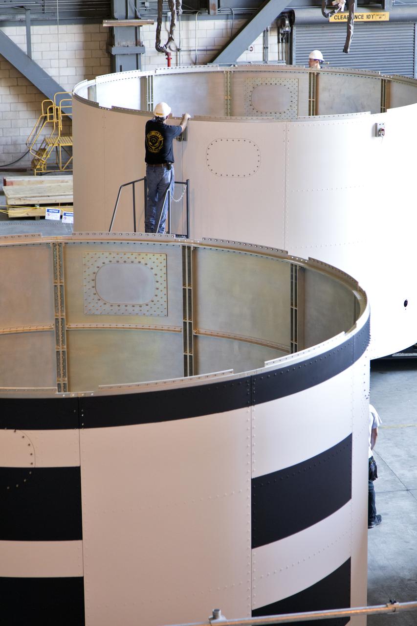 The third and final aeroshell for Orion's Launch Abort System (LAS) is in High Bay 4 of the Vehicle Assembly Building on July 12, 2018, at NASA's Kennedy Space Center in Florida. The aeroshell was shipped from EMF Inc. on nearby Merritt Island. Technicians prepare the aeroshell to be lifted off of the flatbed and transferred to slats. All three aeroshells will be stacked and prepared for a full-stress test of the LAS, called Ascent Abort-2 (AA-2) flight test, scheduled for April 2019. During the test, a booster will launch from Space Launch Complex 46 at Cape Canaveral Air Force Station, carrying a fully functional LAS and a 22,000-pound Orion test vehicle to an altitude of 31,000 feet and traveling at more than 1,000 miles an hour. The test will verify the LAS can steer the crew module and astronauts aboard to safety in the event of an issue with the Space Launch System (SLS) rocket when the spacecraft is under the highest aerodynamic loads it will experience during a rapid climb into space. Orion is being prepared for its first integrated uncrewed flight atop the SLS on Exploration Mission-1.
