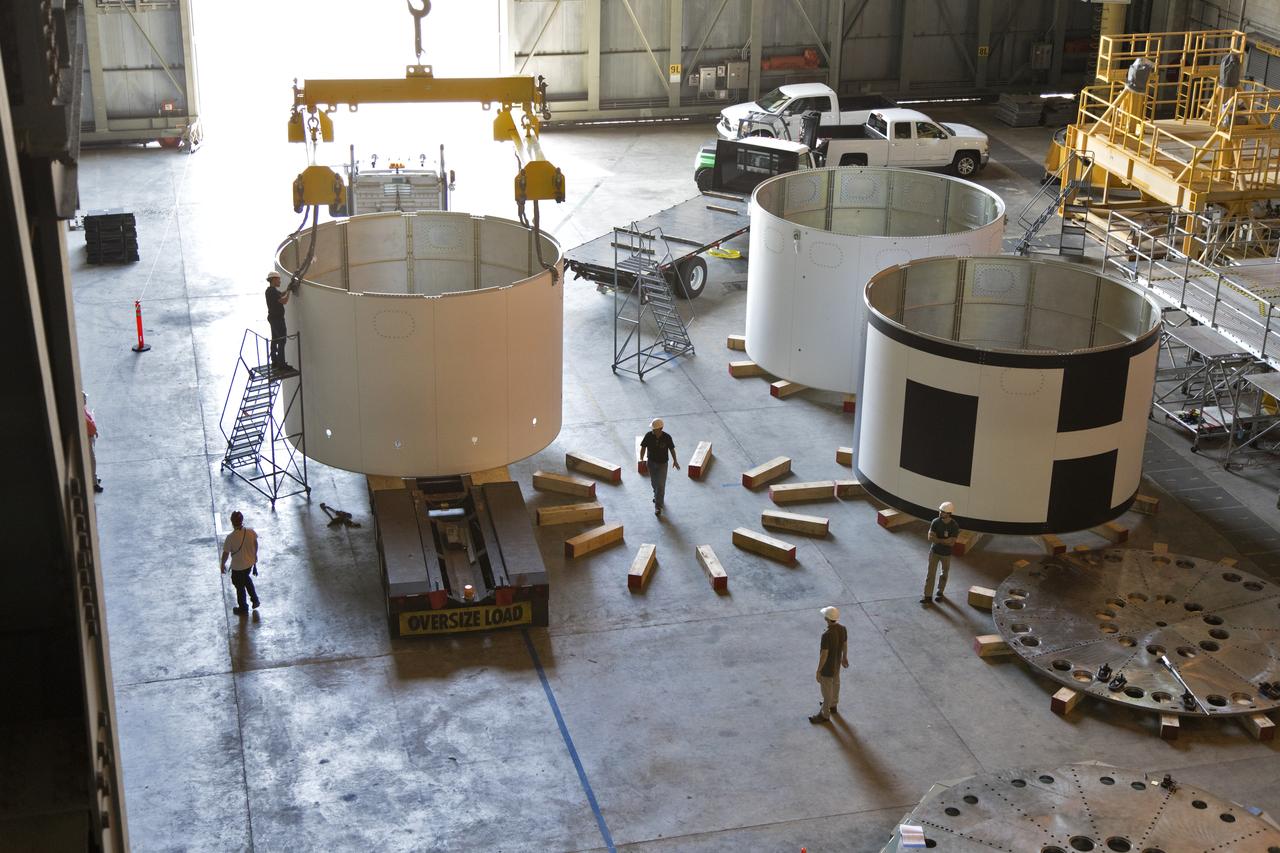 The third and final aeroshell, at left, for Orion's Launch Abort System (LAS) is in High Bay 4 of the Vehicle Assembly Building on July 12, 2018, at NASA's Kennedy Space Center in Florida. The aeroshell was shipped from EMF Inc. on nearby Merritt Island. Technicians prepare the aeroshell to be lifted off of the flatbed truck and transferred to slats. All three aeroshells will be stacked and prepared for a full-stress test of the LAS, called Ascent Abort-2 (AA-2) flight test, scheduled for April 2019. During the test, a booster will launch from Space Launch Complex 46 at Cape Canaveral Air Force Station, carrying a fully functional LAS and a 22,000-pound Orion test vehicle to an altitude of 31,000 feet and traveling at more than 1,000 miles an hour. The test will verify the LAS can steer the crew module and astronauts aboard to safety in the event of an issue with the Space Launch System (SLS) rocket when the spacecraft is under the highest aerodynamic loads it will experience during a rapid climb into space. Orion is being prepared for its first integrated uncrewed flight atop the SLS on Exploration Mission-1.