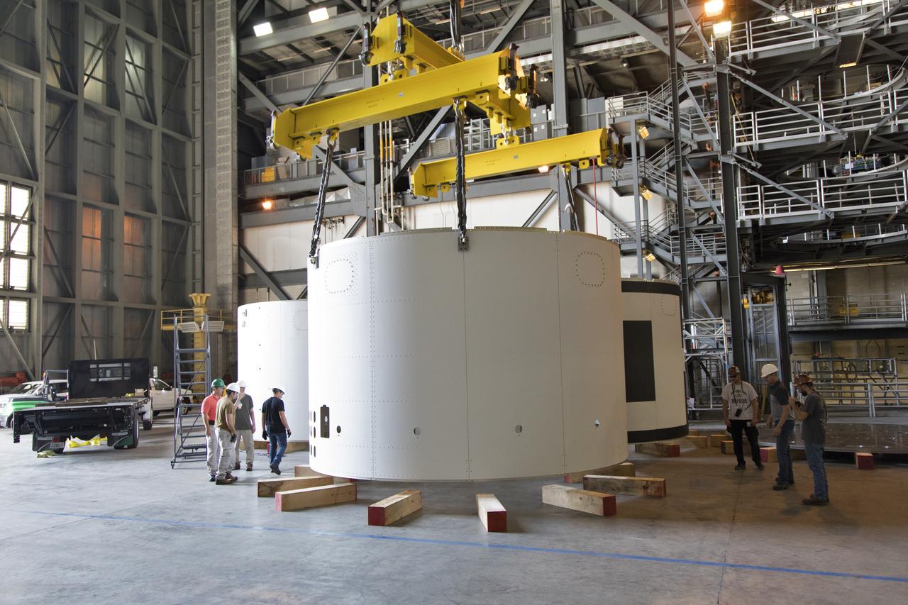 A crane lowers the third and final aeroshell for Orion's Launch Abort System (LAS) onto slats in High Bay 4 of the Vehicle Assembly Building on July 12, 2018, at NASA's Kennedy Space Center in Florida. The aeroshell was shipped from EMF Inc. on nearby Merritt Island. All three aeroshells will be stacked and prepared for a full-stress test of the LAS, called Ascent Abort-2 (AA-2) flight test, scheduled for April 2019. During the test, a booster will launch from Space Launch Complex 46 at Cape Canaveral Air Force Station, carrying a fully functional LAS and a 22,000-pound Orion test vehicle to an altitude of 31,000 feet and traveling at more than 1,000 miles an hour. The test will verify the LAS can steer the crew module and astronauts aboard to safety in the event of an issue with the Space Launch System (SLS) rocket when the spacecraft is under the highest aerodynamic loads it will experience during a rapid climb into space. Orion is being prepared for its first integrated uncrewed flight atop the SLS on Exploration Mission-1.