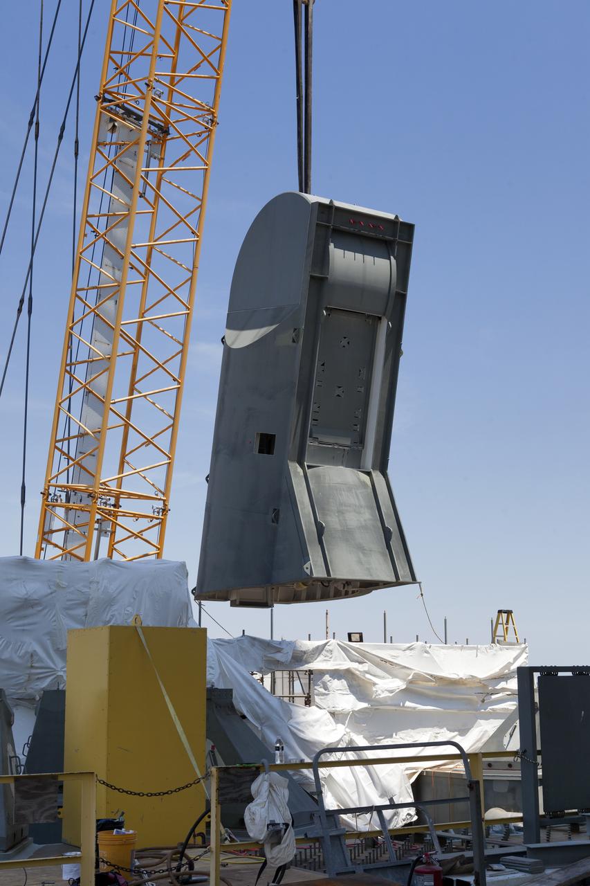 A crane is used to lift up the first of two Tail Service Mast Umbilicals for installation on the 0-level deck of the mobile launcher on July 12, at NASA's Kennedy Space Center in Florida. The 35-foot-tall umbilical will connect to NASA's Space Launch System rocket core stage aft section and provide liquid oxygen and electrical cable connections to the core stage engine section to support propellant handling during prelaunch operations. The installation brings Exploration Ground Systems one step closer to supporting prelaunch operations for the agency's SLS rocket and Orion spacecraft on Exploration Mission-1 and deep space destinations.