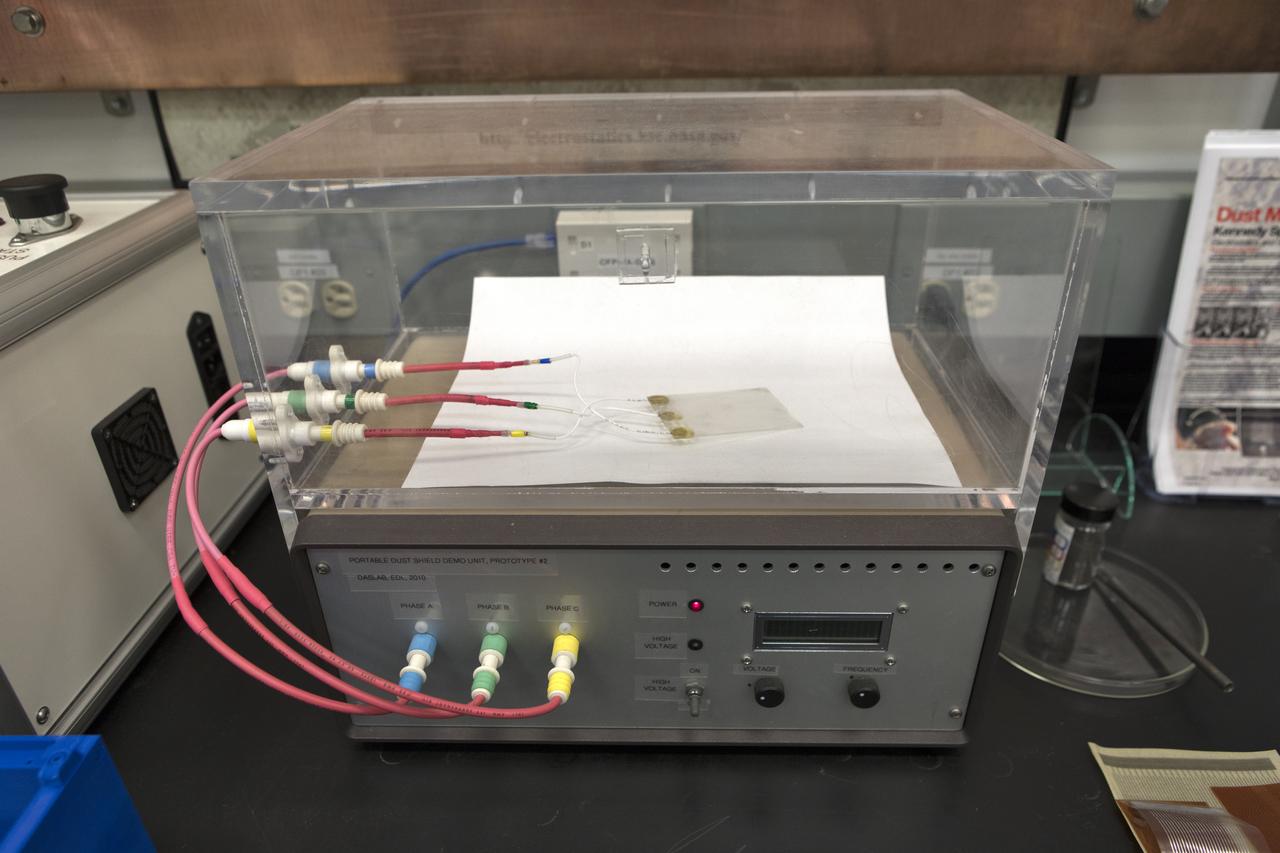 In the Electrostatics and Surface Physics Laboratory at NASA's Kennedy Space Center in Florida, an Electrostatic Dust Shield is prepared for testing on Thursday, July 19, 2018. Scientists are developing the Electrostatic Dust Shield to help mitigate the problem of dust on equipment, space suits and helmet visors of astronauts exploring the Moon or Mars. The device is slated for analysis aboard International Space Station in the spring of 2019 to verify the effects of the space environment.
