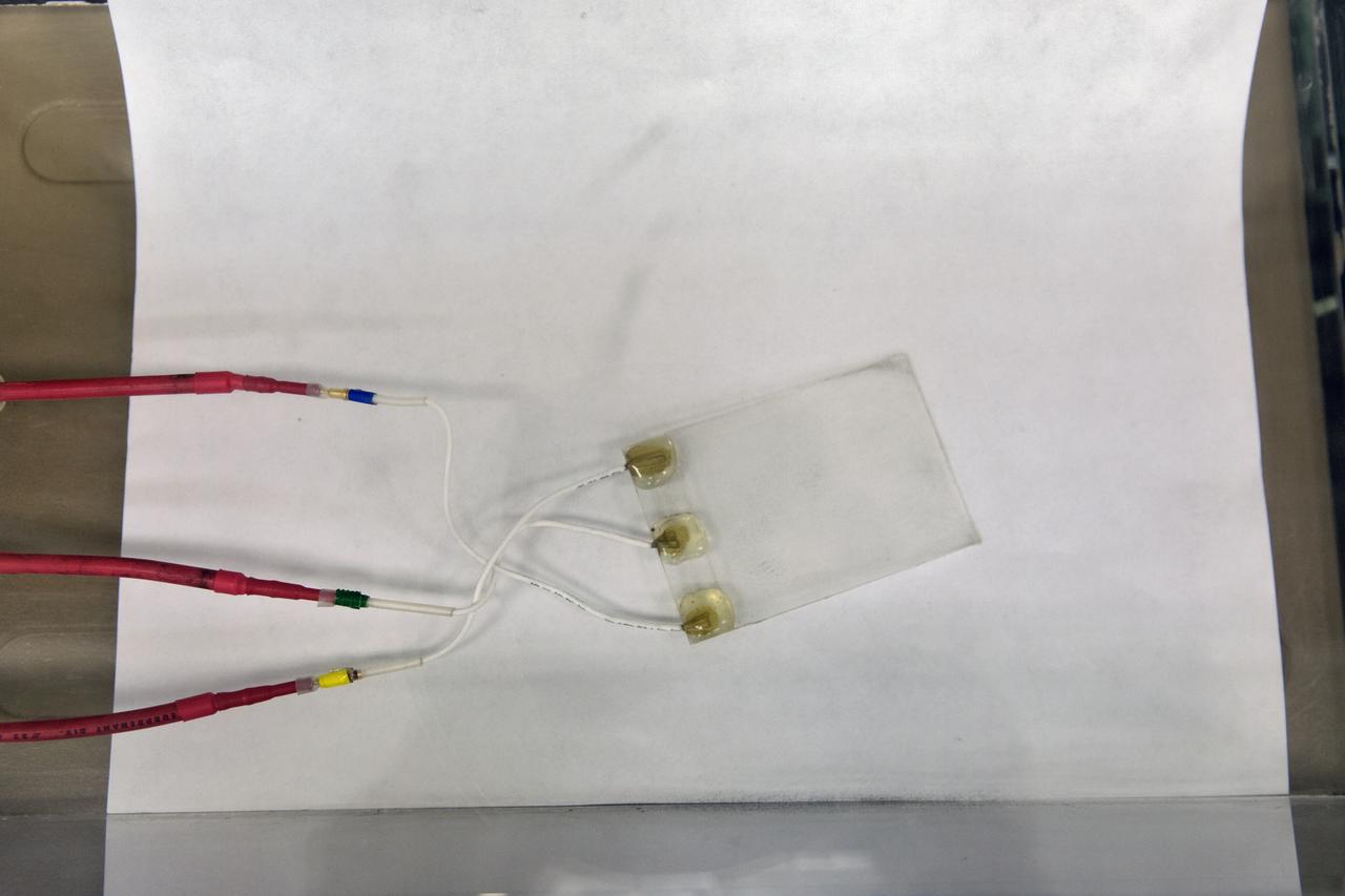 In the Electrostatics and Surface Physics Laboratory at NASA's Kennedy Space Center in Florida, an Electrostatic Dust Shield is prepared for testing on Thursday, July 19, 2018. Scientists are developing the Electrostatic Dust Shield to help mitigate the problem of dust on equipment, space suits and helmet visors of astronauts exploring the Moon or Mars. The device is slated for analysis aboard International Space Station in the spring of 2019 to verify the effects of the space environment.