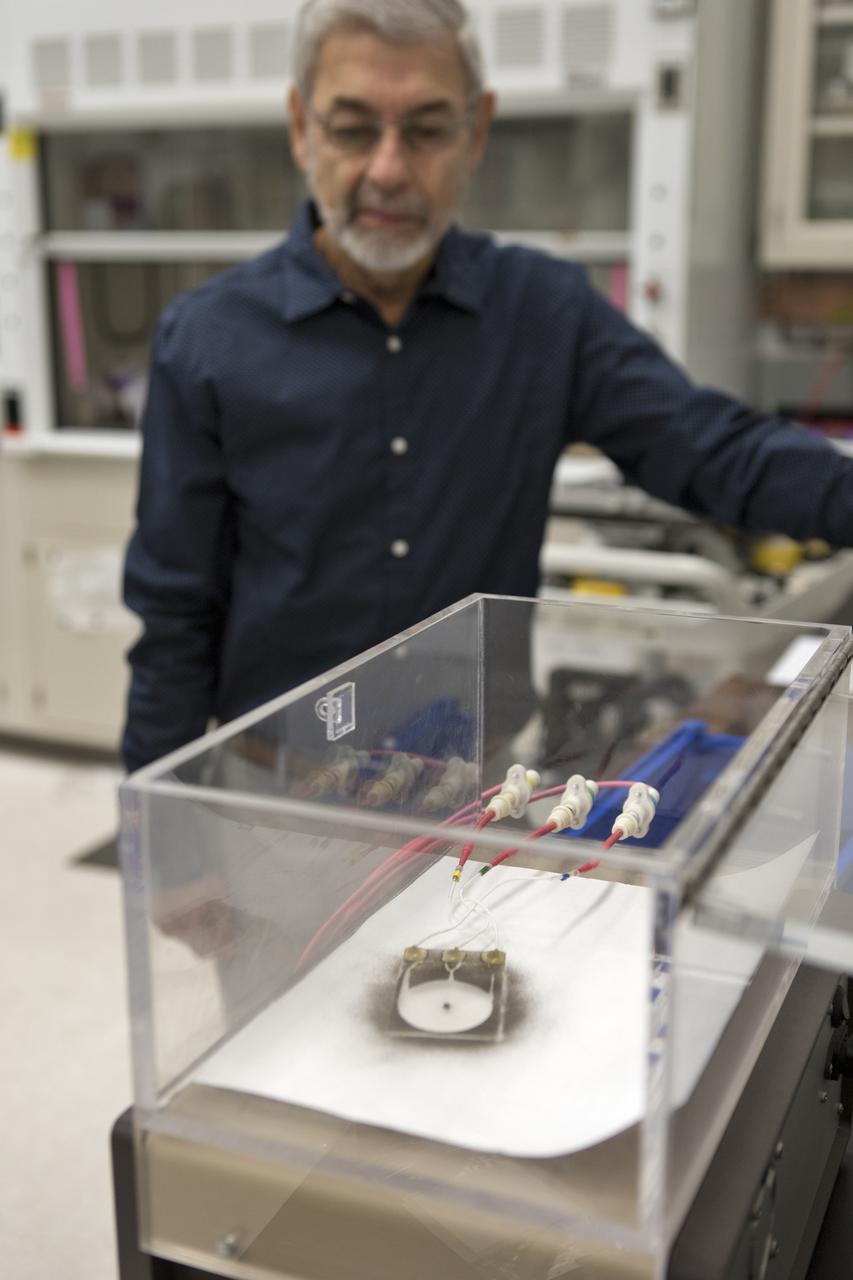 On Thursday, July 19, 2018, Dr. Carlos Calle, lead scientist in the Electrostatics and Surface Physics Laboratory at NASA's Kennedy Space Center in Florida, activates an experiment in which an Electrostatic Dust Shield has been covered with dust similar to that which may be encountered by astronauts exploring the Moon or Mars. When activated, the device shakes off the dust. Scientists are developing the dust shield to help mitigate the problem of dust on equipment, astronauts' space suits and helmet visors. The device is slated for analysis aboard International Space Station in the spring of 2019 to verify the effects of the space environment.