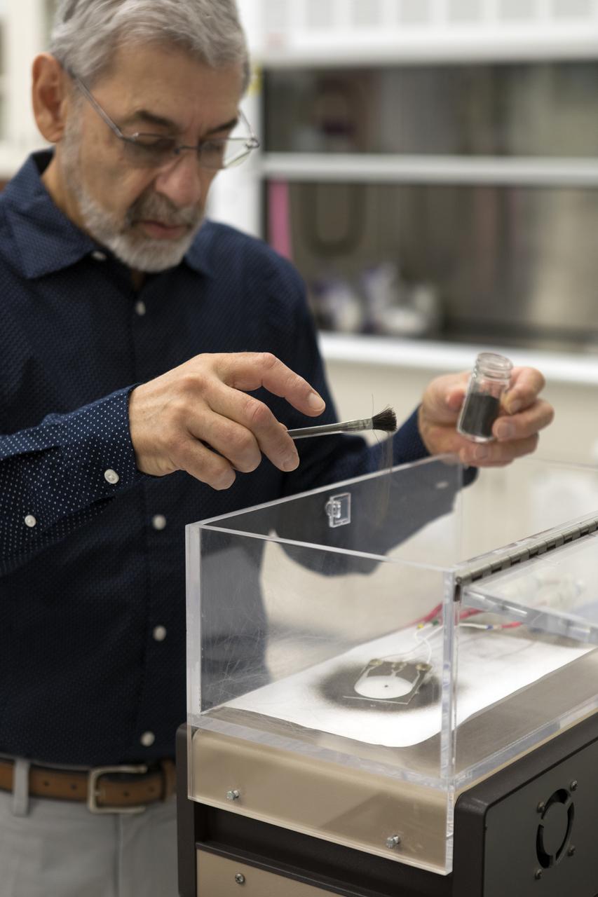 Dr. Carlos Calle, lead scientist in the Electrostatics and Surface Physics Laboratory at NASA's Kennedy Space Center in Florida, prepares an Electrostatic Dust Shield for testing on Thursday, July 19, 2018. Scientists are developing the Electrostatic Dust Shield to help mitigate the problem of dust on equipment, astronauts' space suits and helmet visors of astronauts exploring the Moon or Mars. The device is slated for analysis aboard International Space Station in the spring of 2019 to verify the effects of the space environment.